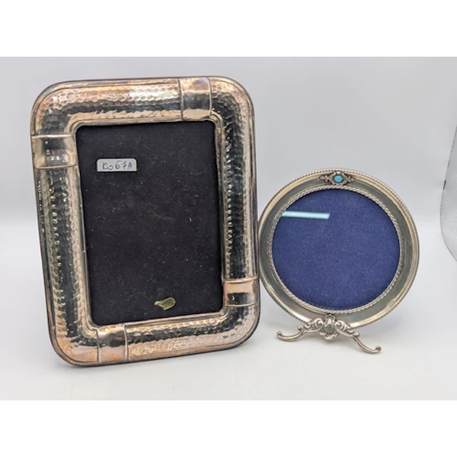 Two silver fronted easel back photograph frames, one in circ...