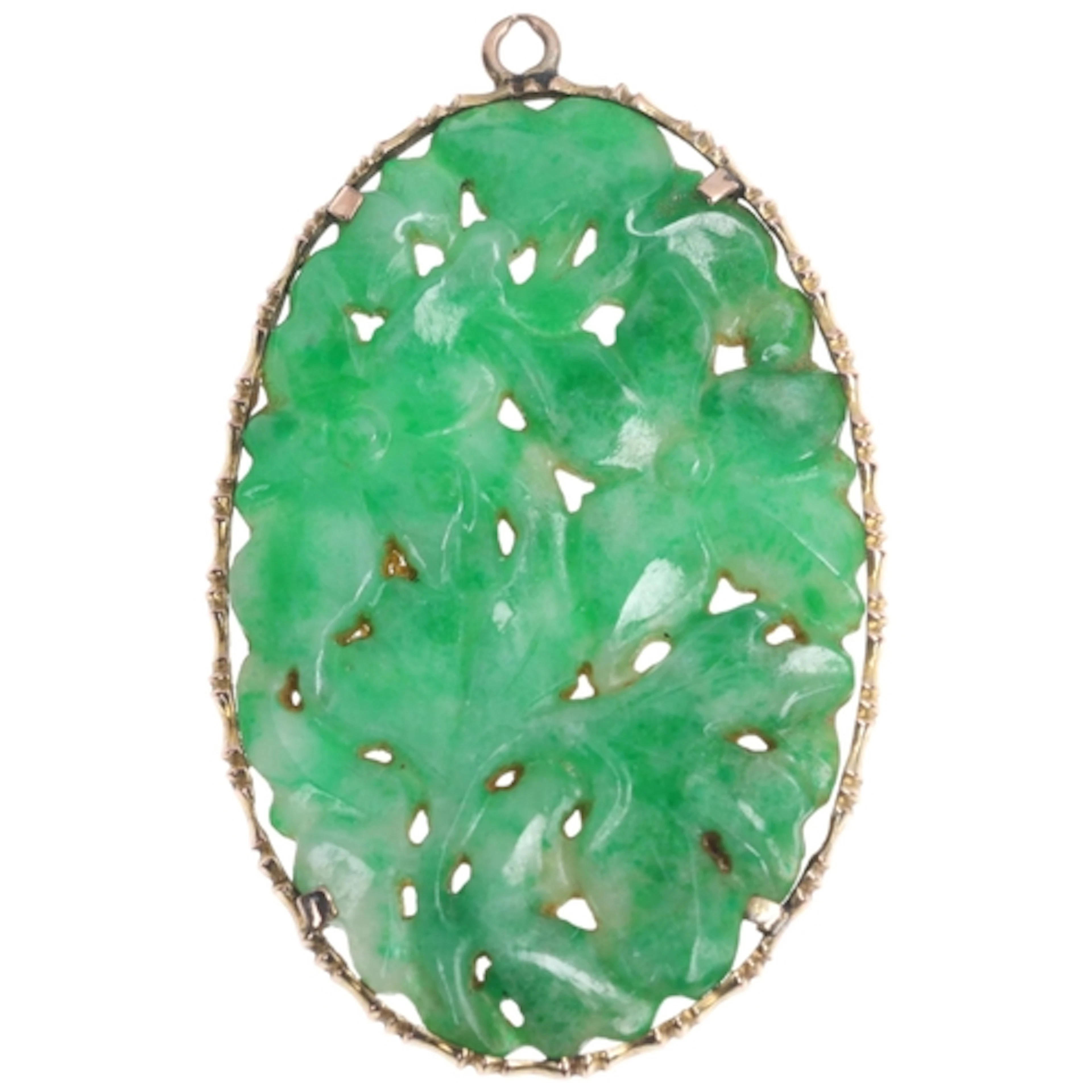 A Chinese jade floral pendant, the oval panel relief carved ...