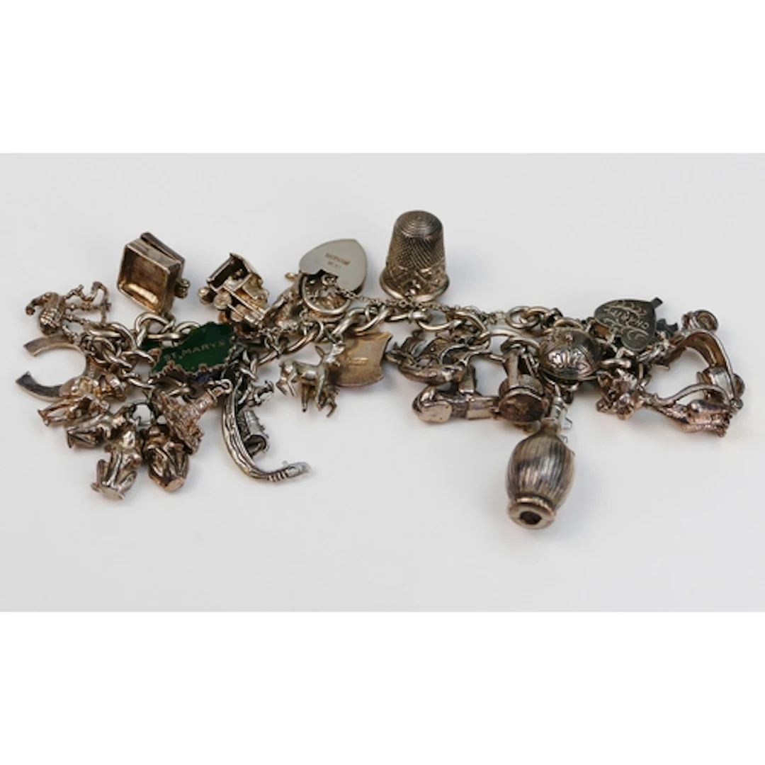 A silver charm bracelet with heart padlock clasp, charms inc...