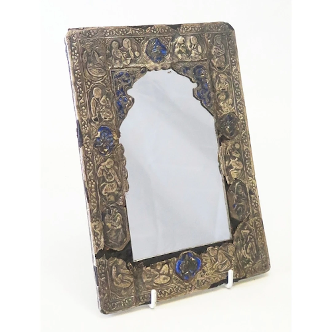 A Persian silver and enamel mirror, the arched mirror plated...