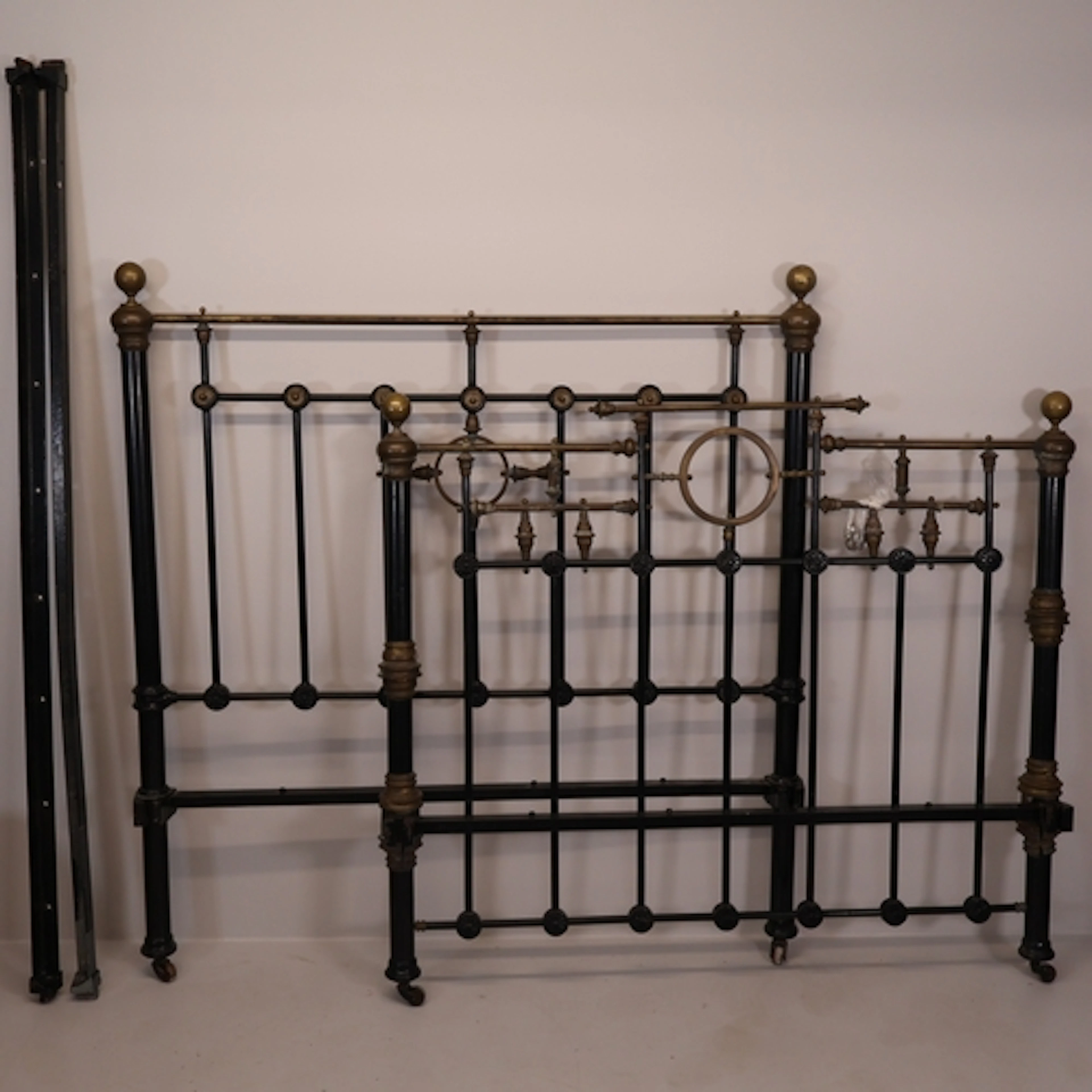 An antique brass and cast iron 4'6" double bed frame, compri...