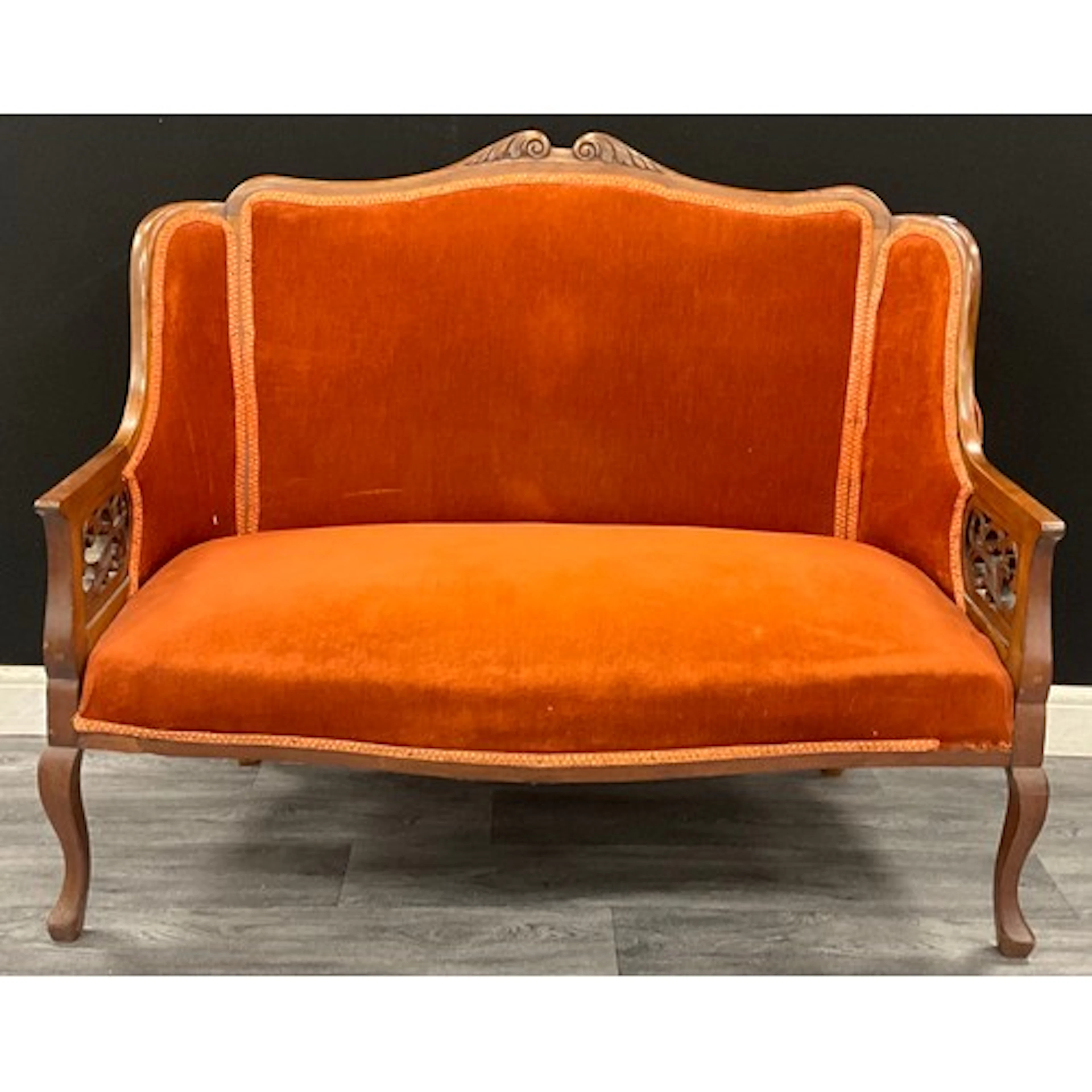 A late Victorian mahogany drawing room sofa, the ends carved...