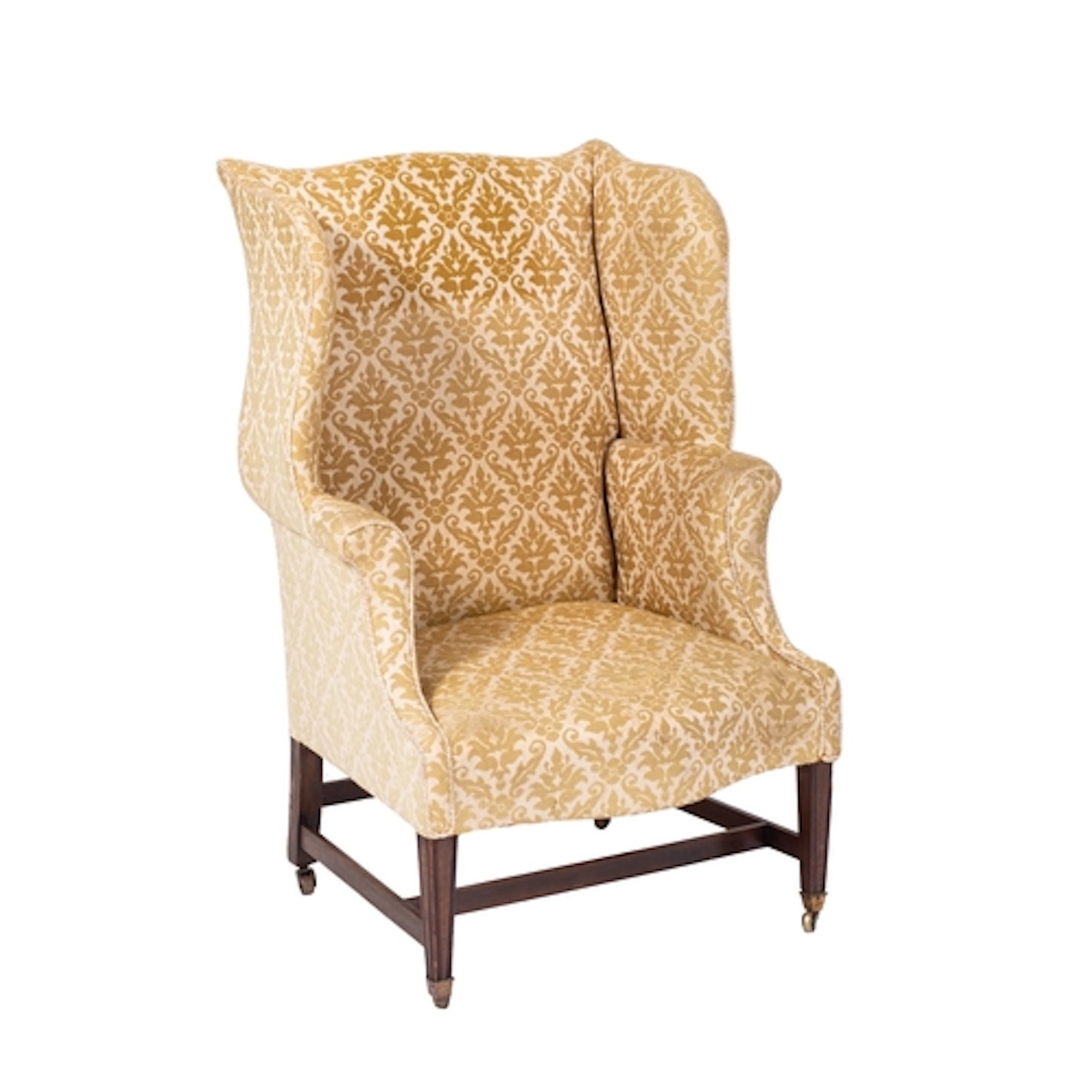 A stained beech wing frame armchair in the George III manner...