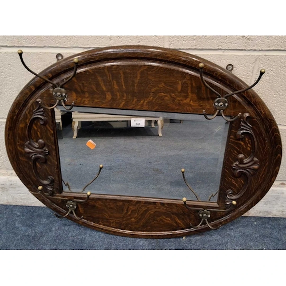 A 20TH CENTURY OVAL OAK FRAME BEVELLED EDGE WALL MIRROR, wit...