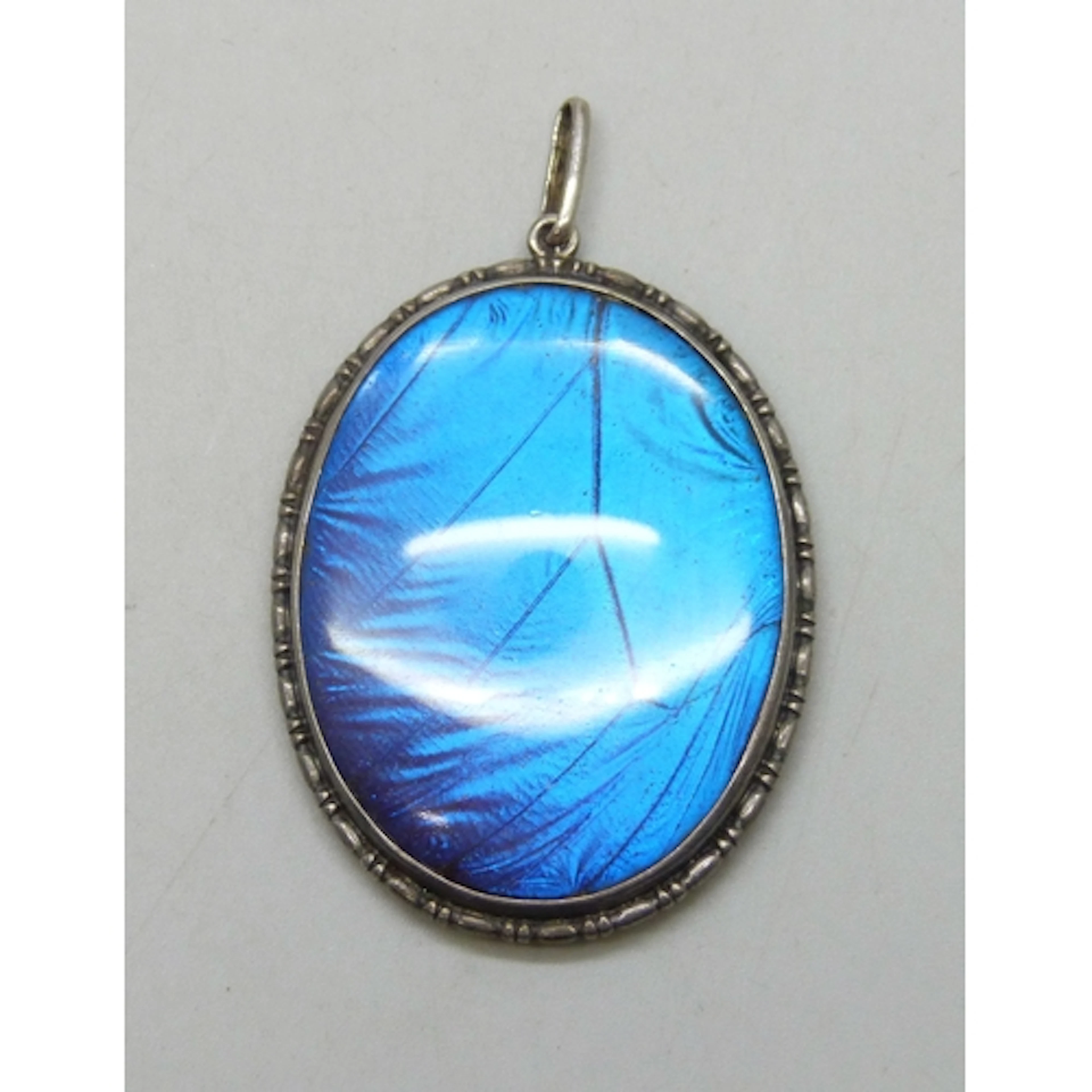 A large Art Deco statement silver and butterfly wing pendant...