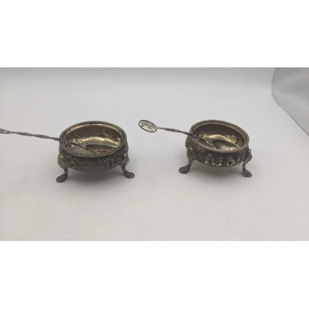 A pair of silver salts on pawed feet, having a gilt interior...