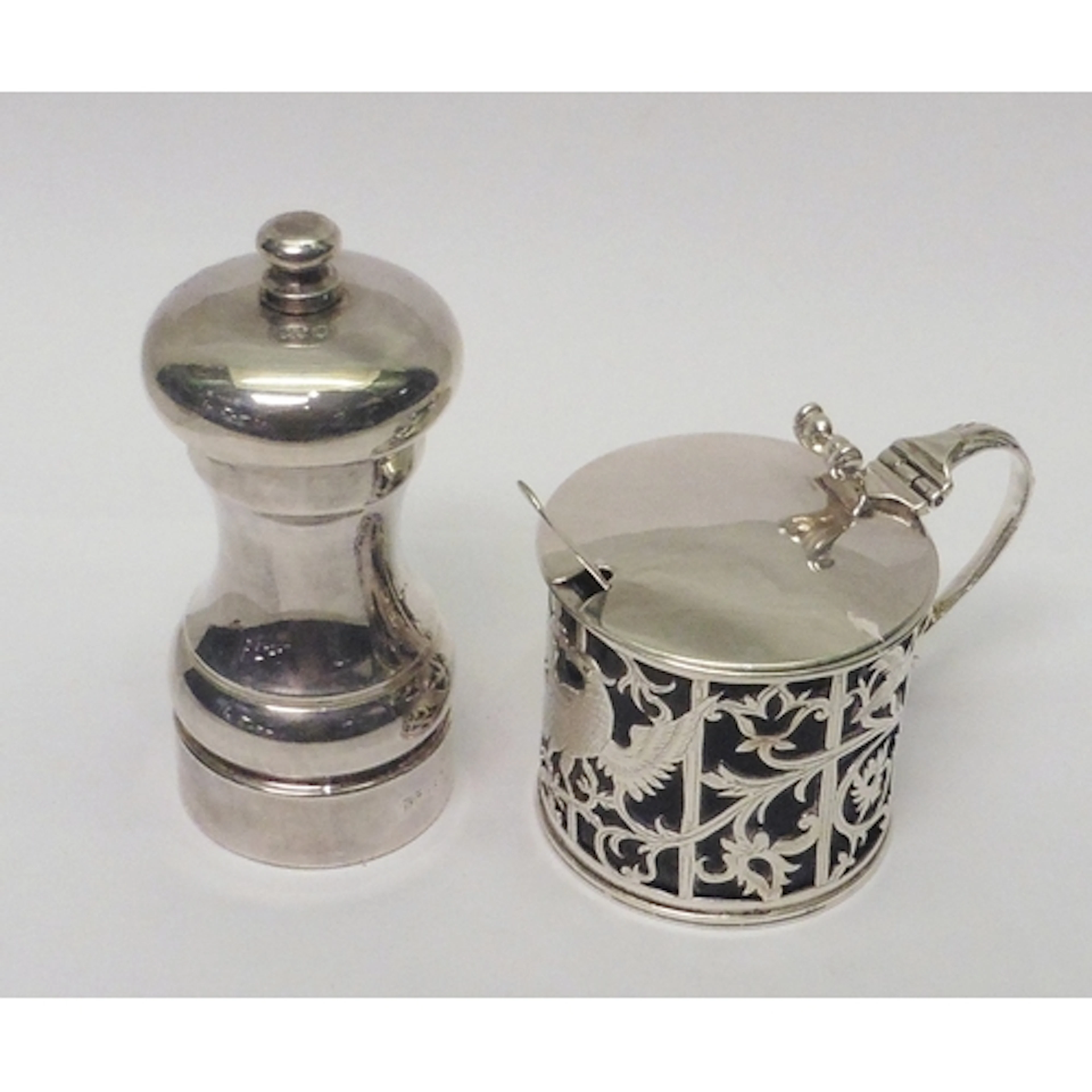 A late Victorian mustard pot, pierced and chased silver with...