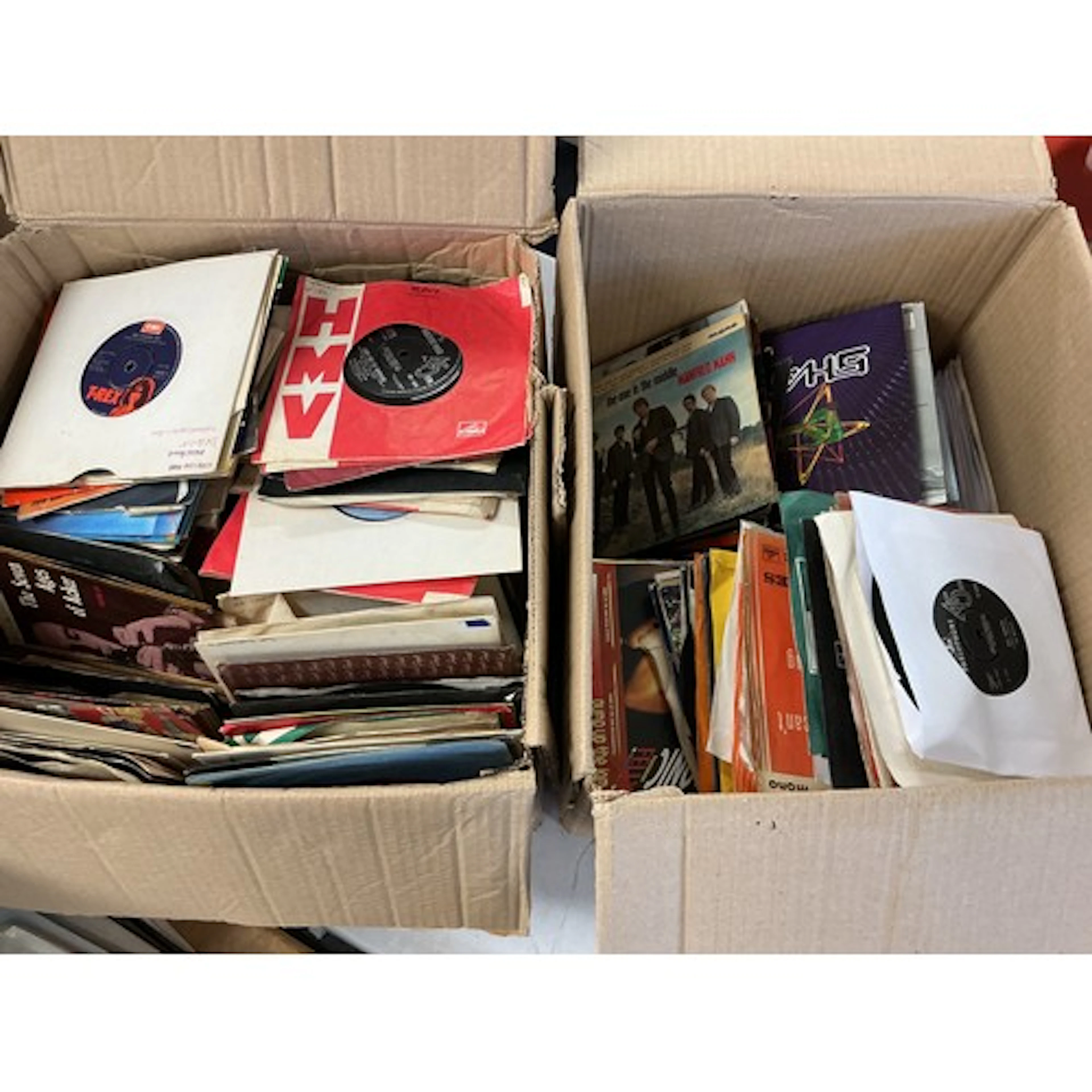 Two boxes of 7” singles and EPs by various artists including...