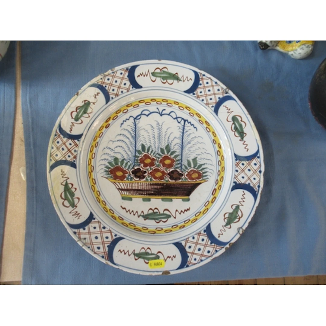An 18th century Delft charger, decorated with a basket of fl...