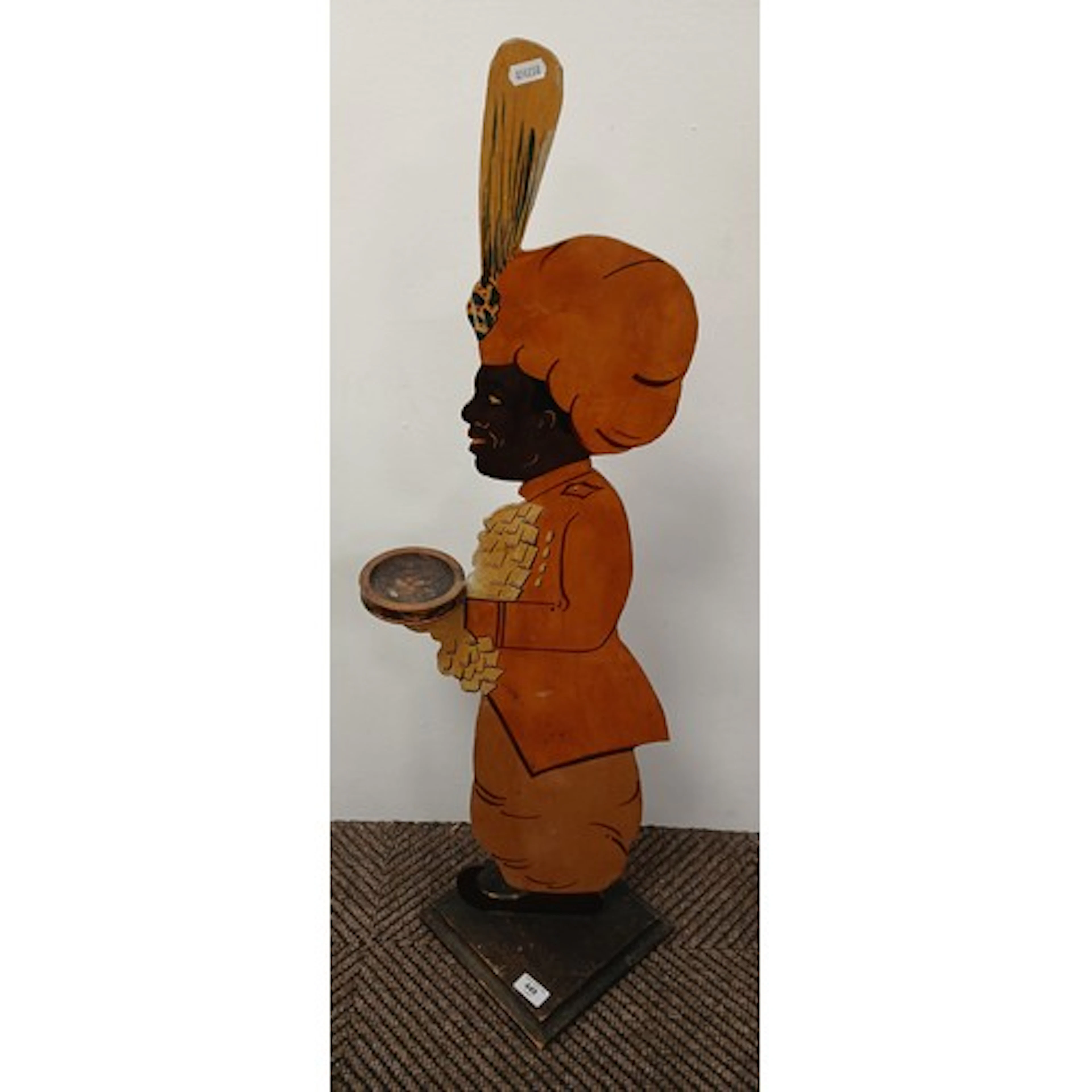 Carved wooden dummy board depicting a figure in a turban, ho...