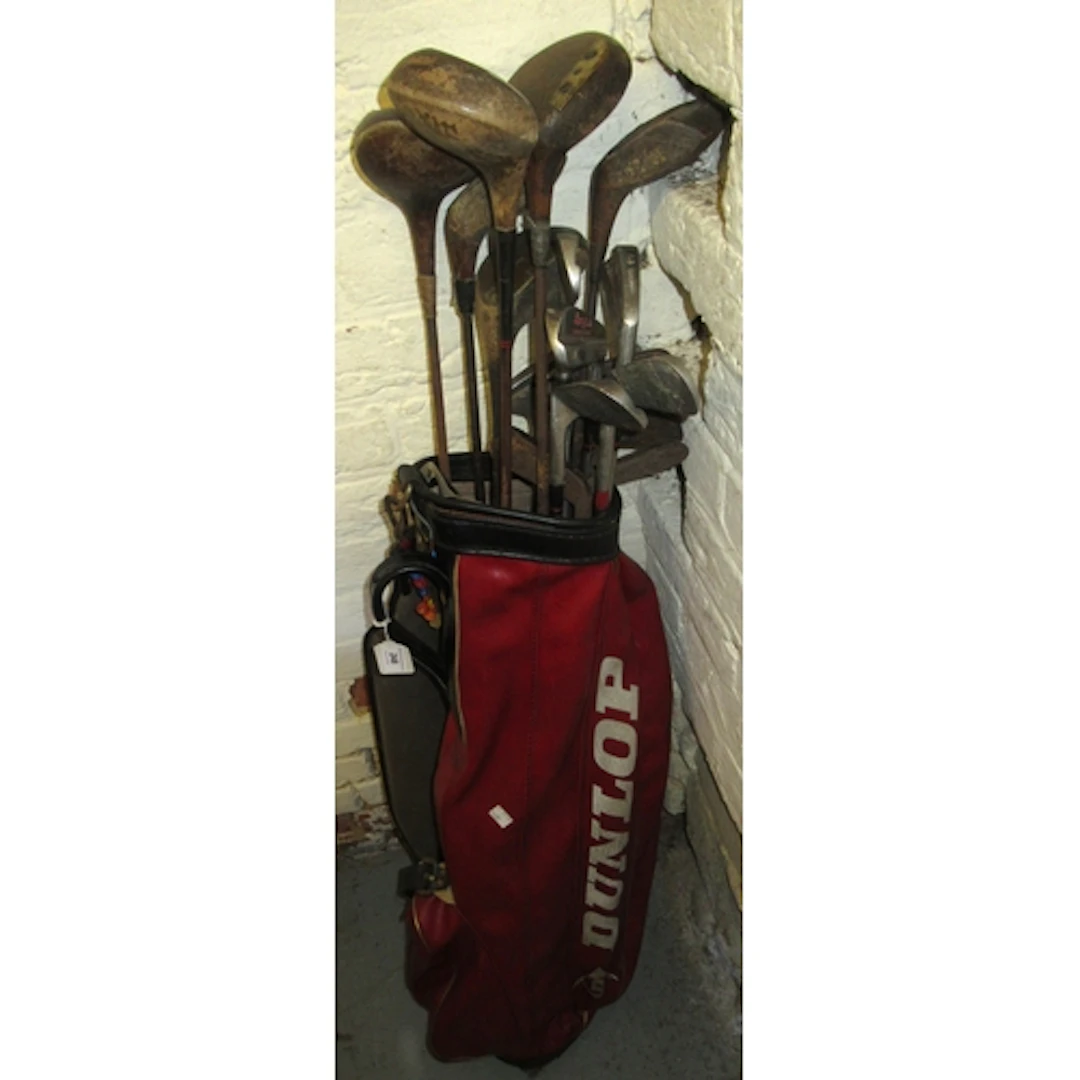 Quantity of various hickory and other golf clubs, in red Dun...