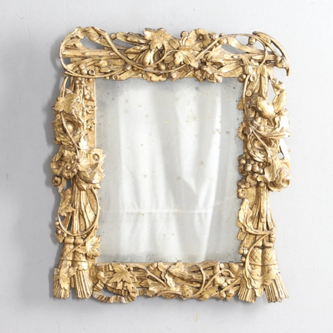 AN ORNATE 19TH CENTURY GILTWOOD WALL MIRROR. the frame carve...