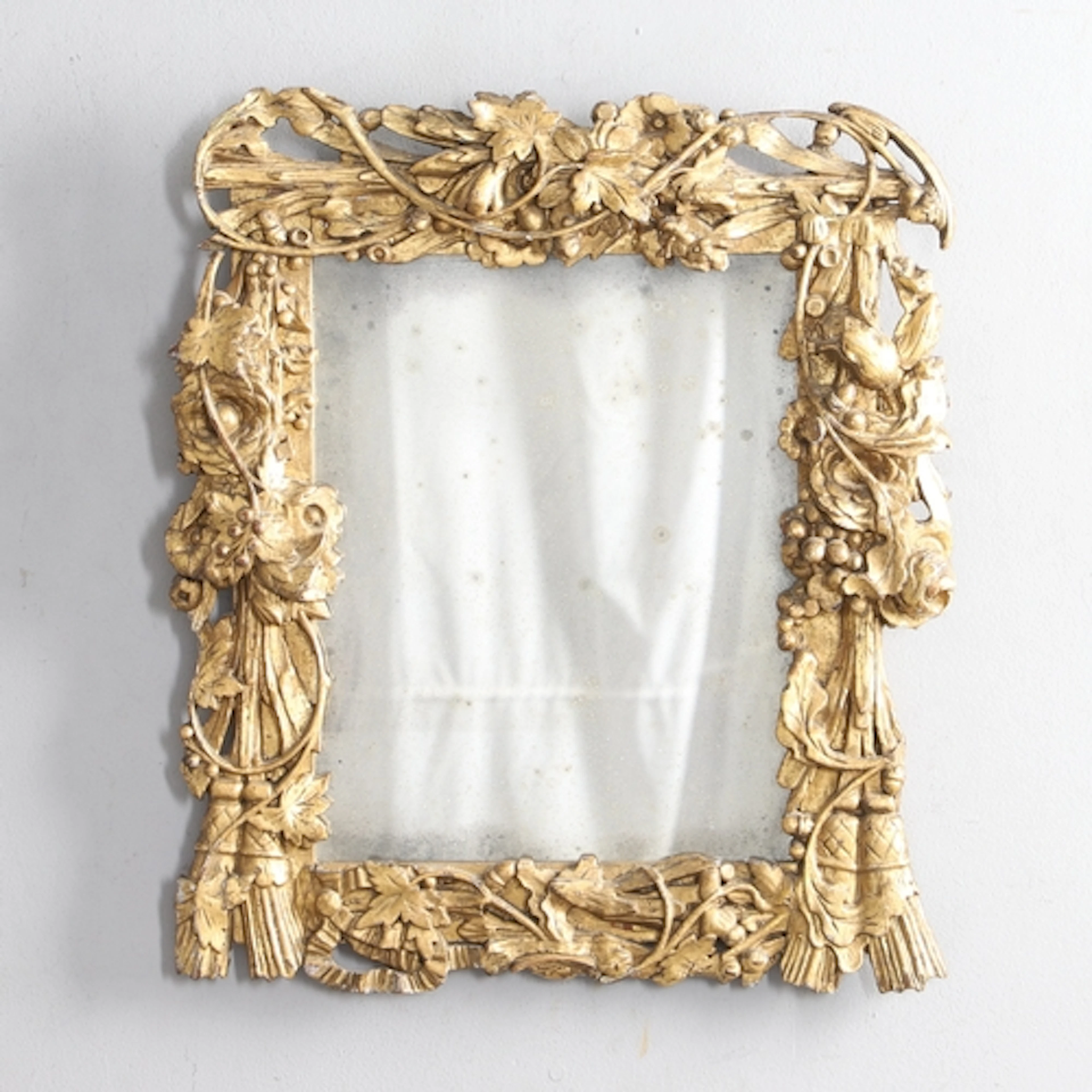 AN ORNATE 19TH CENTURY GILTWOOD WALL MIRROR. the frame carve...