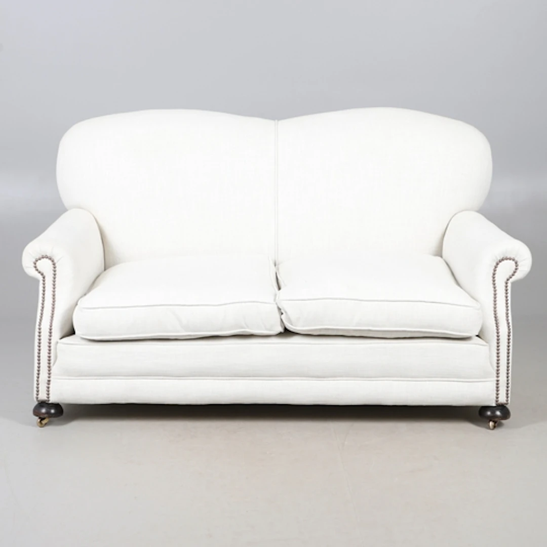 A LATE VICTORIAN TWO SEATER SOFA. the curved back to scrolli...