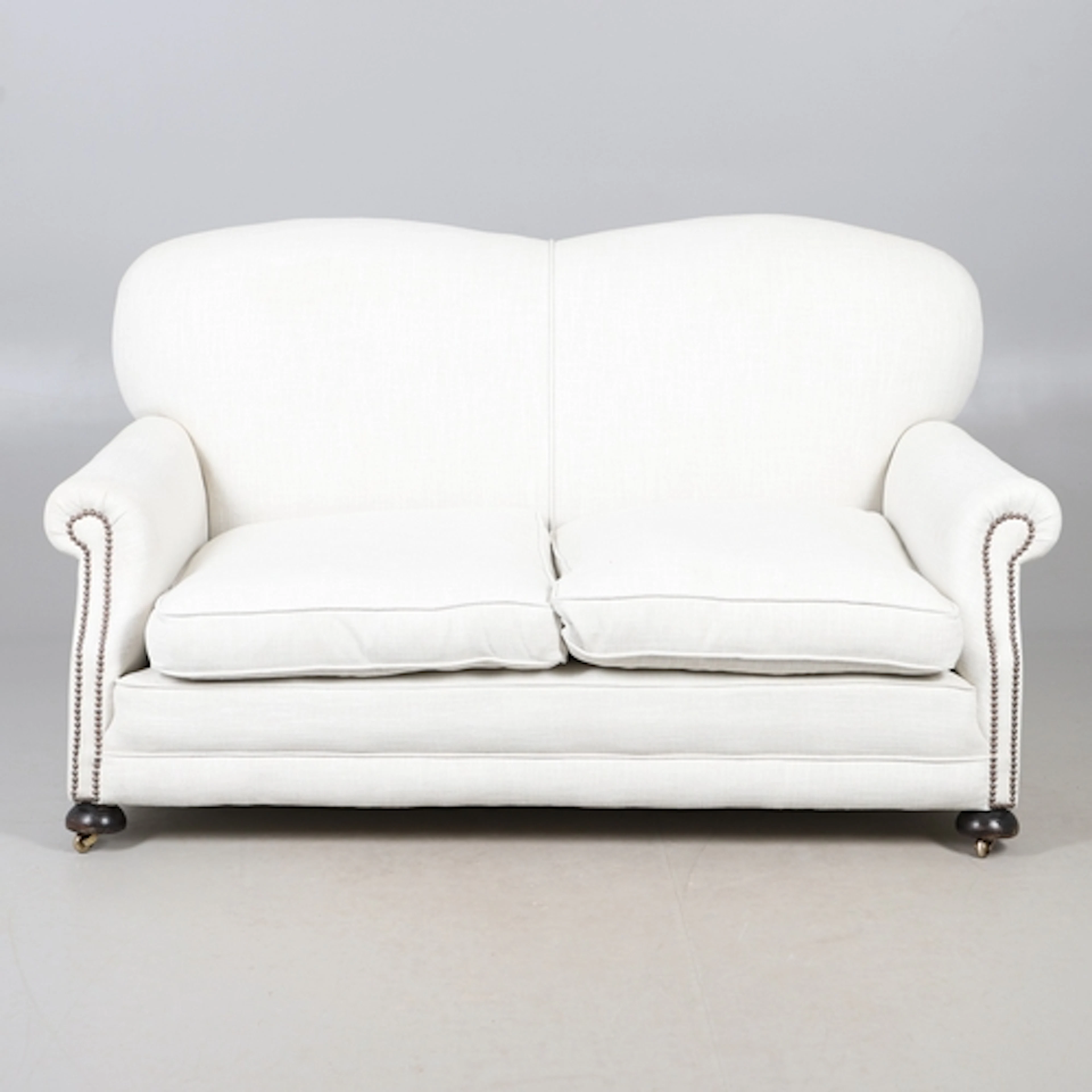 A LATE VICTORIAN TWO SEATER SOFA. the curved back to scrolli...