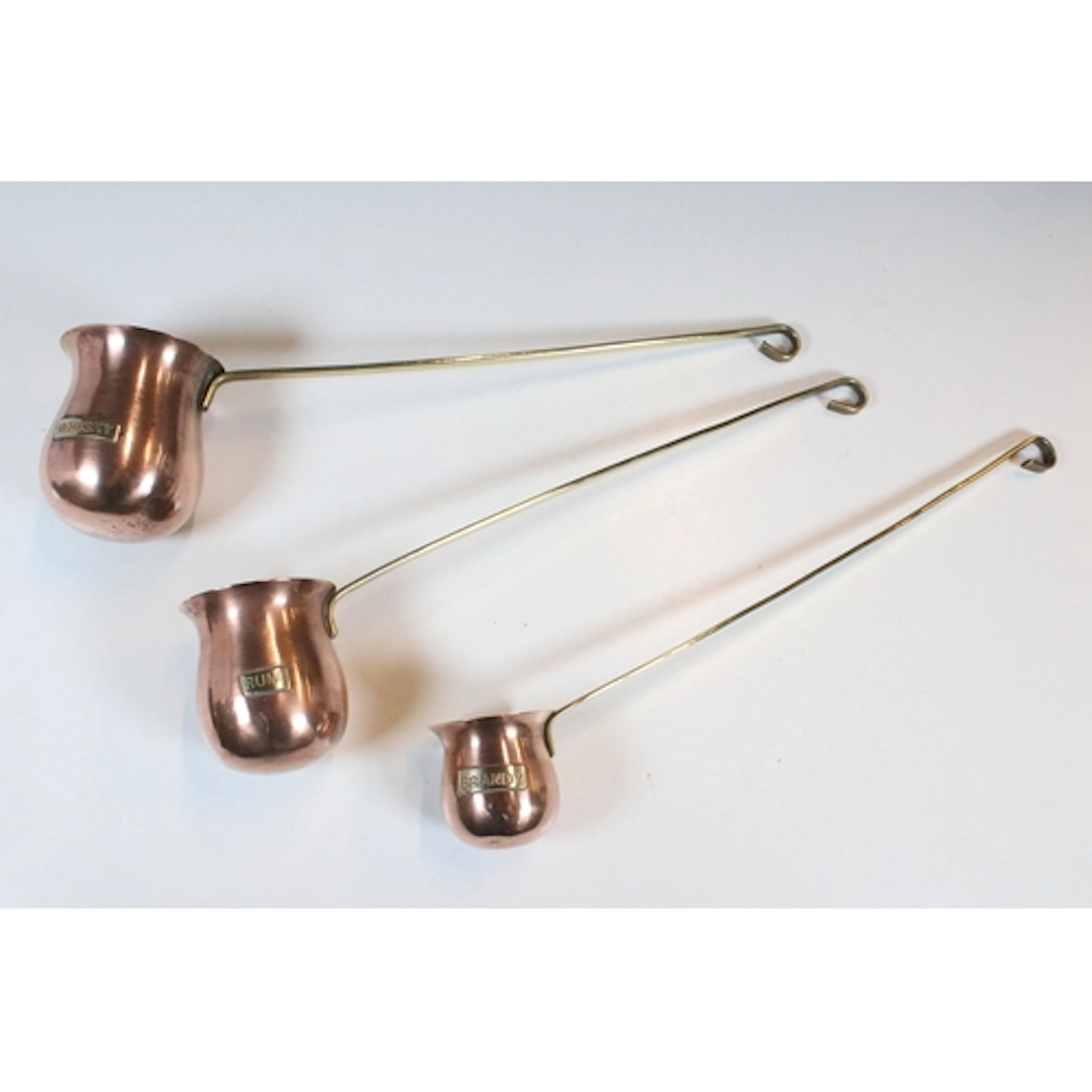 Three copper hanging graduated spirit measures - Whisky, Rum...