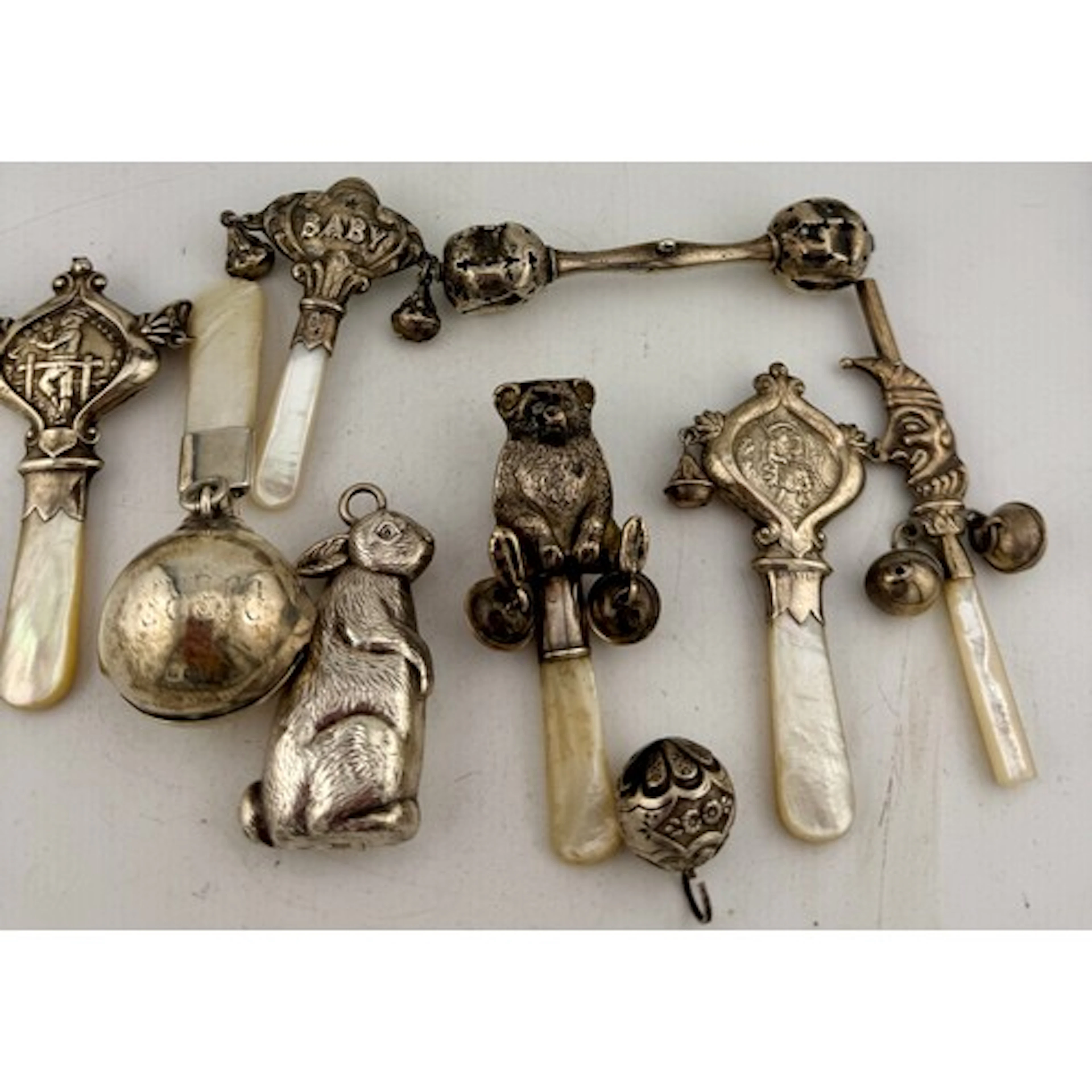 A collection of hallmarked and sterling silver baby rattles ...