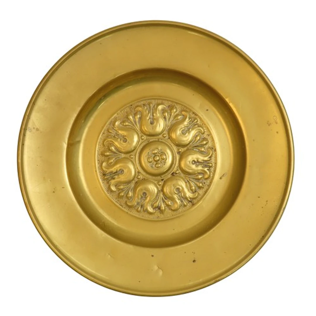 A BRASS ALMS DISH the plain border with a central stylised f...