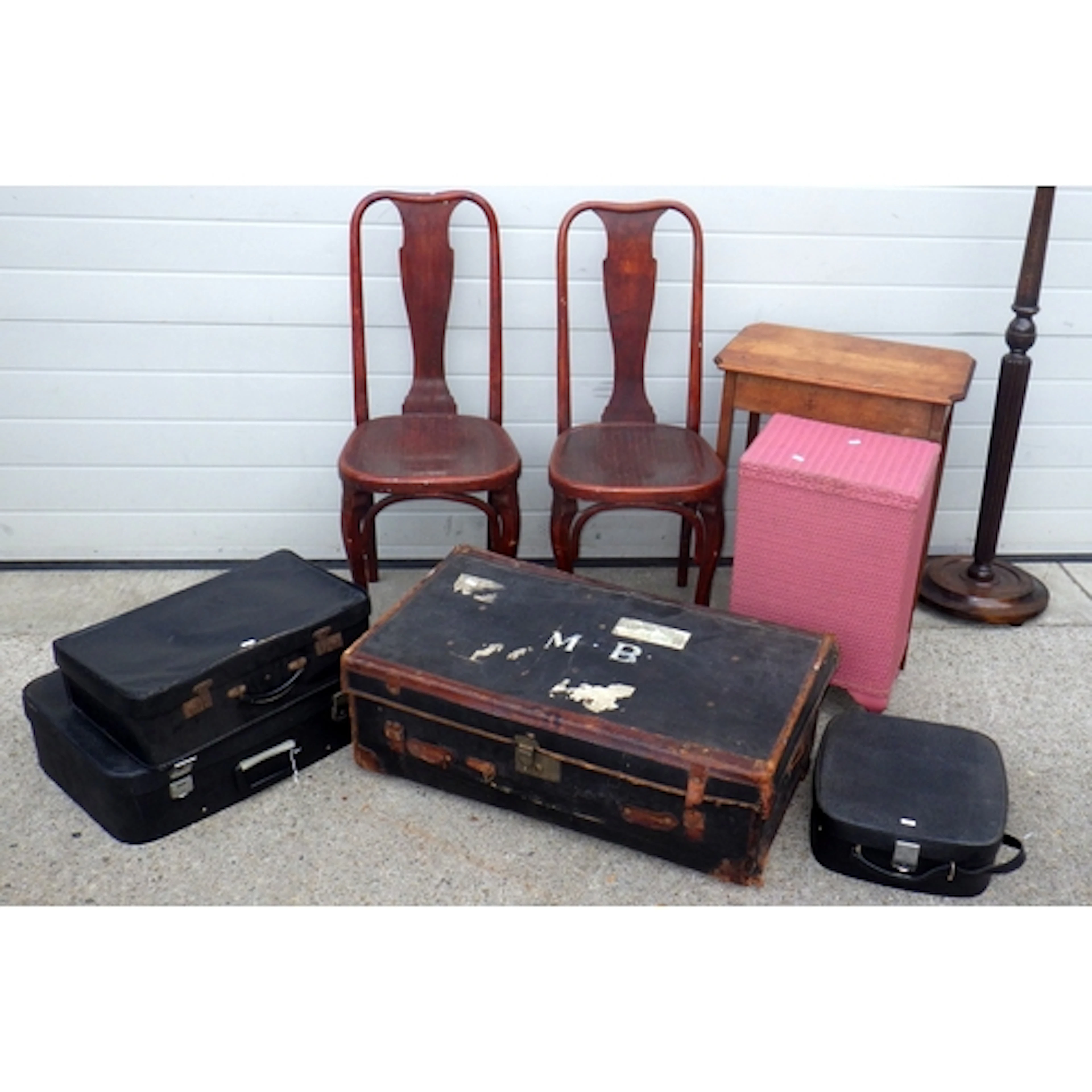 A black canvas trunk, three suitcases, lamp standard, pink l...