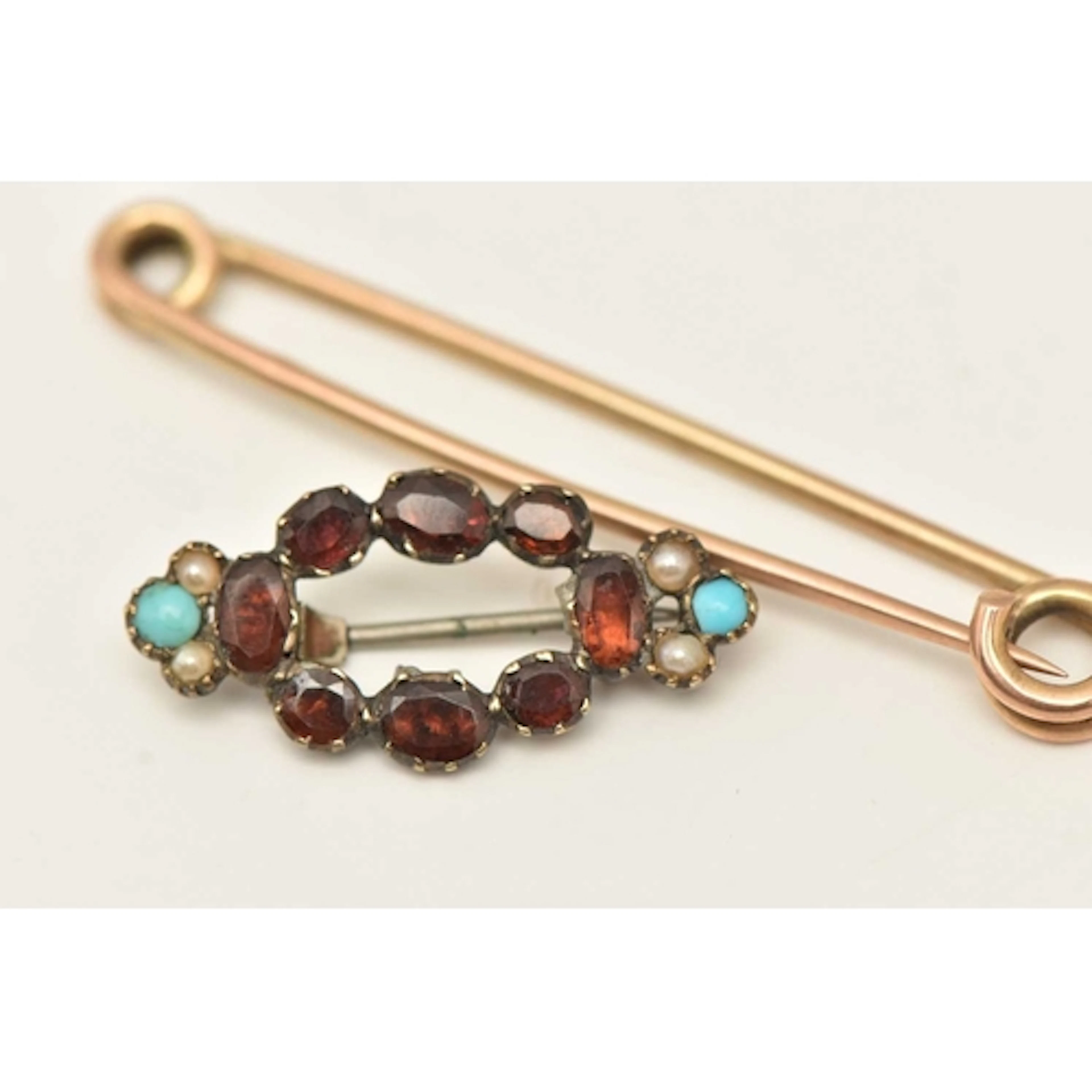 TWO BROOCHES, the first a yellow metal safety pin brooch, st...