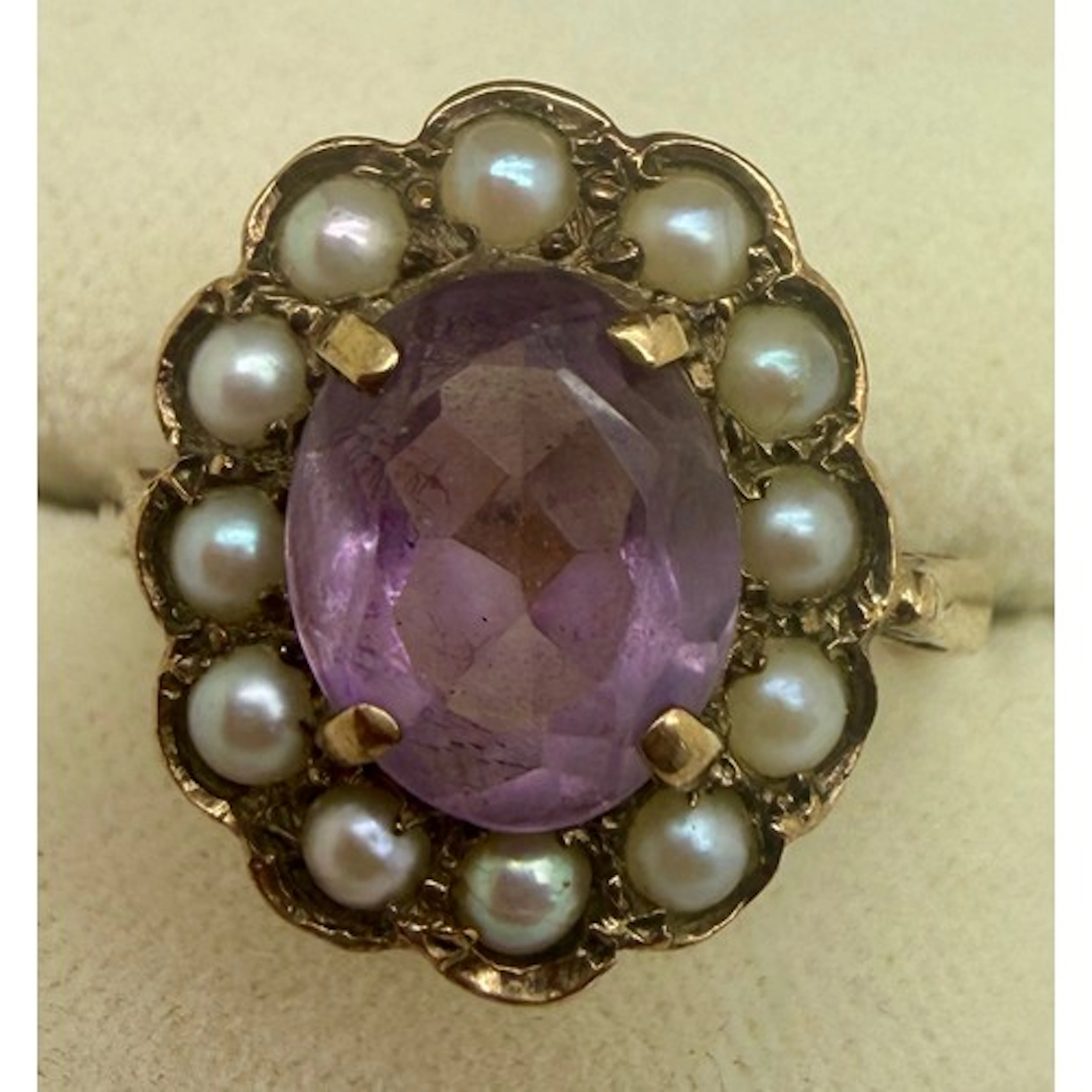 A 9 carat gold cluster ring set with amethyst surrounded by ...