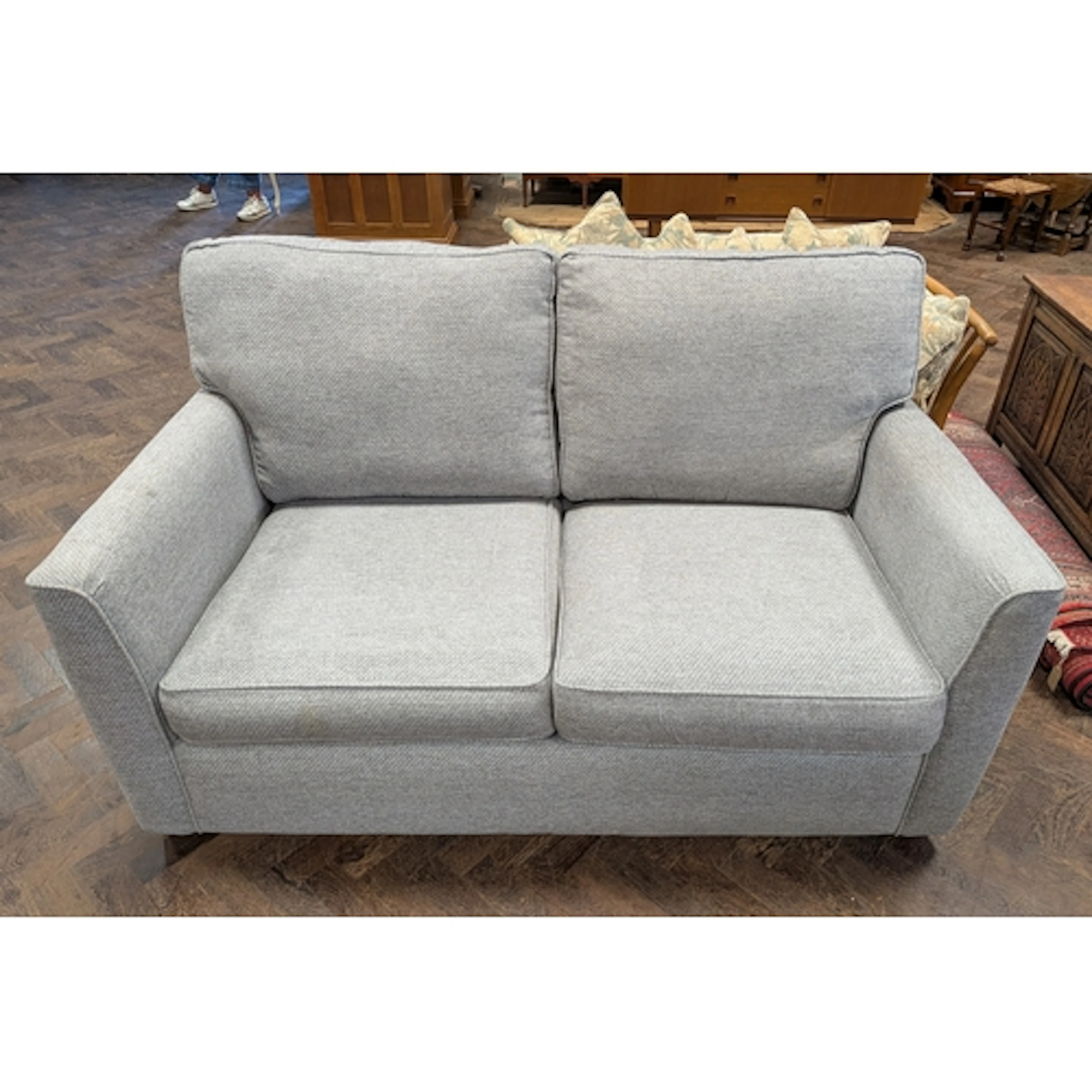 A modern two seater bed settee in grey covering with loose c...