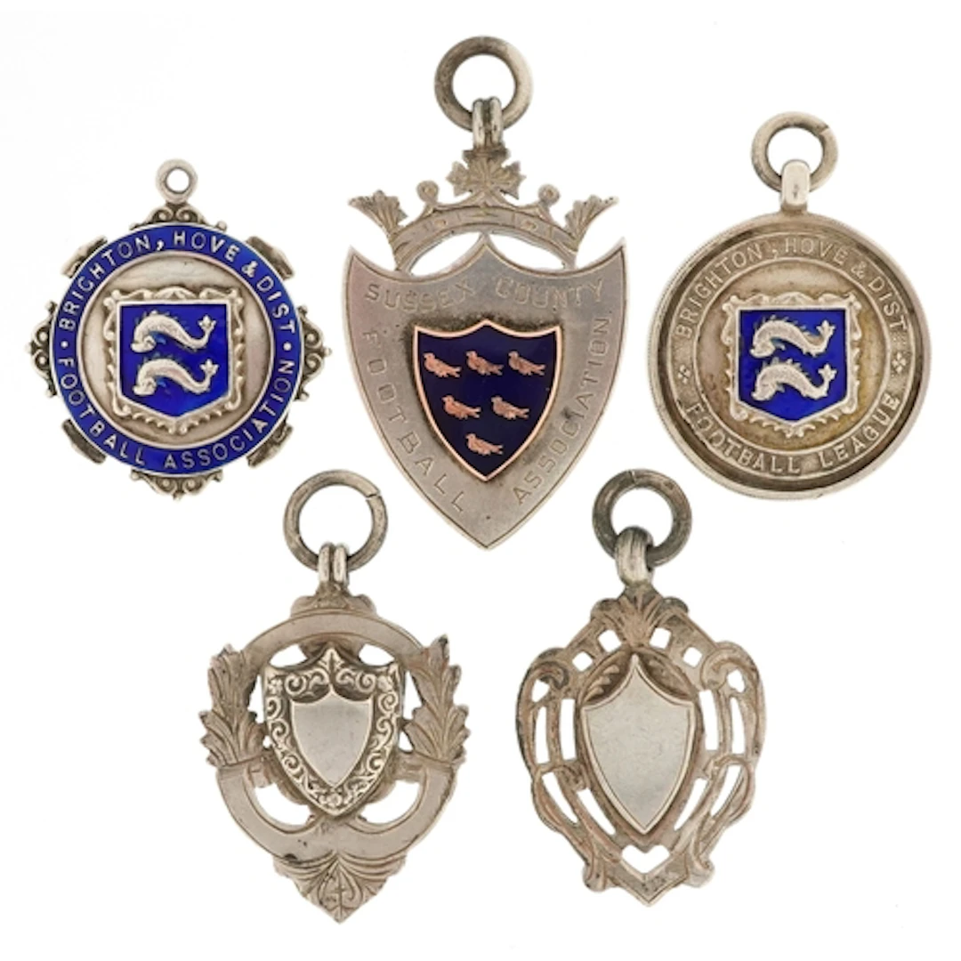 Five early 20th century silver sports jewels, some enamelled...