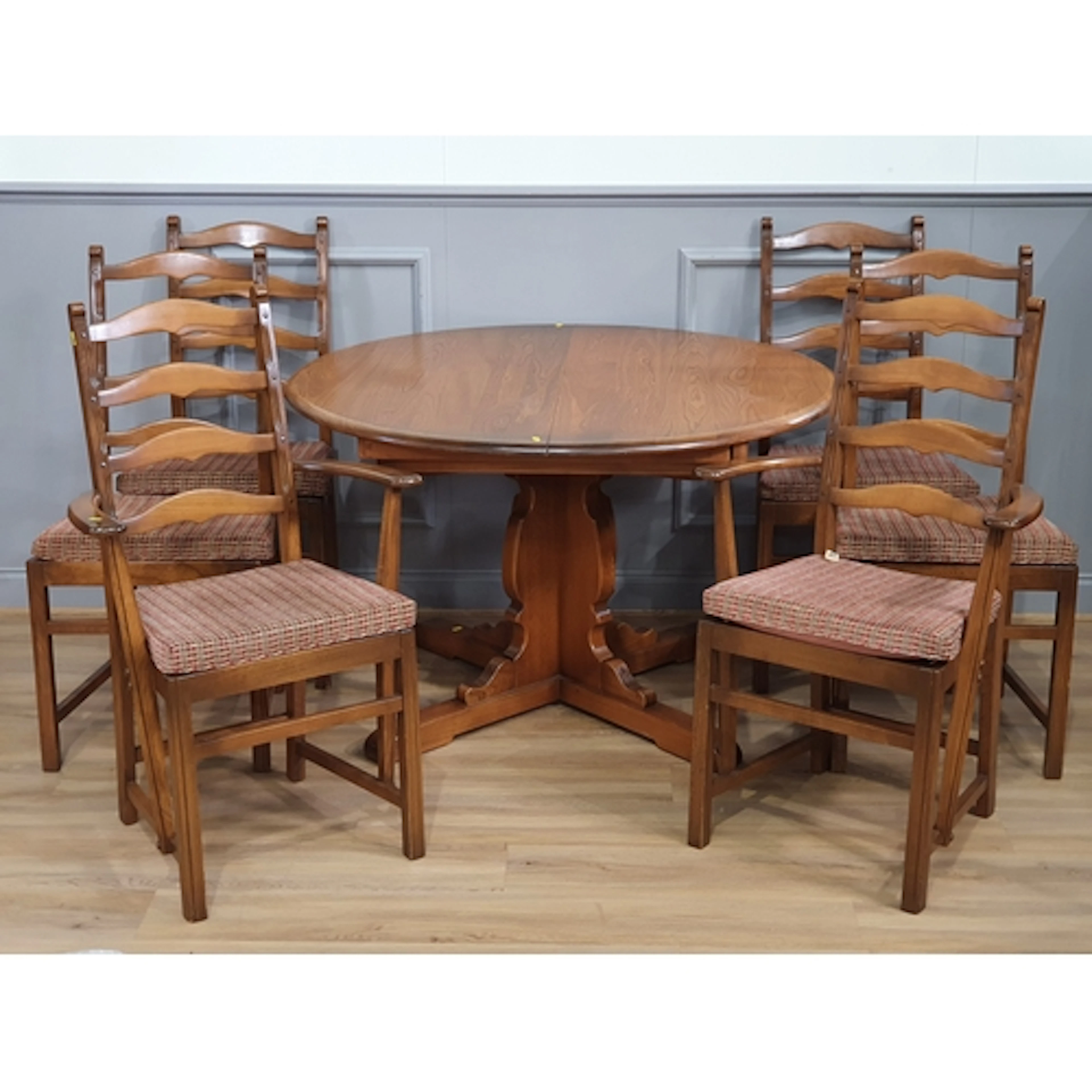 An Ercol circular extending Dining Table and a set of six Er...