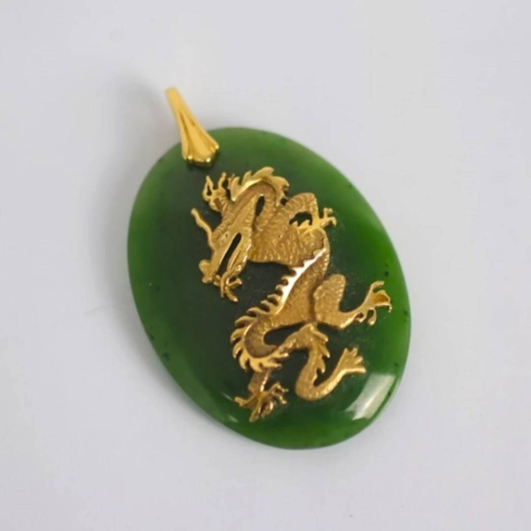 A late 20th century nephrite pendant, the oval slice of neph...
