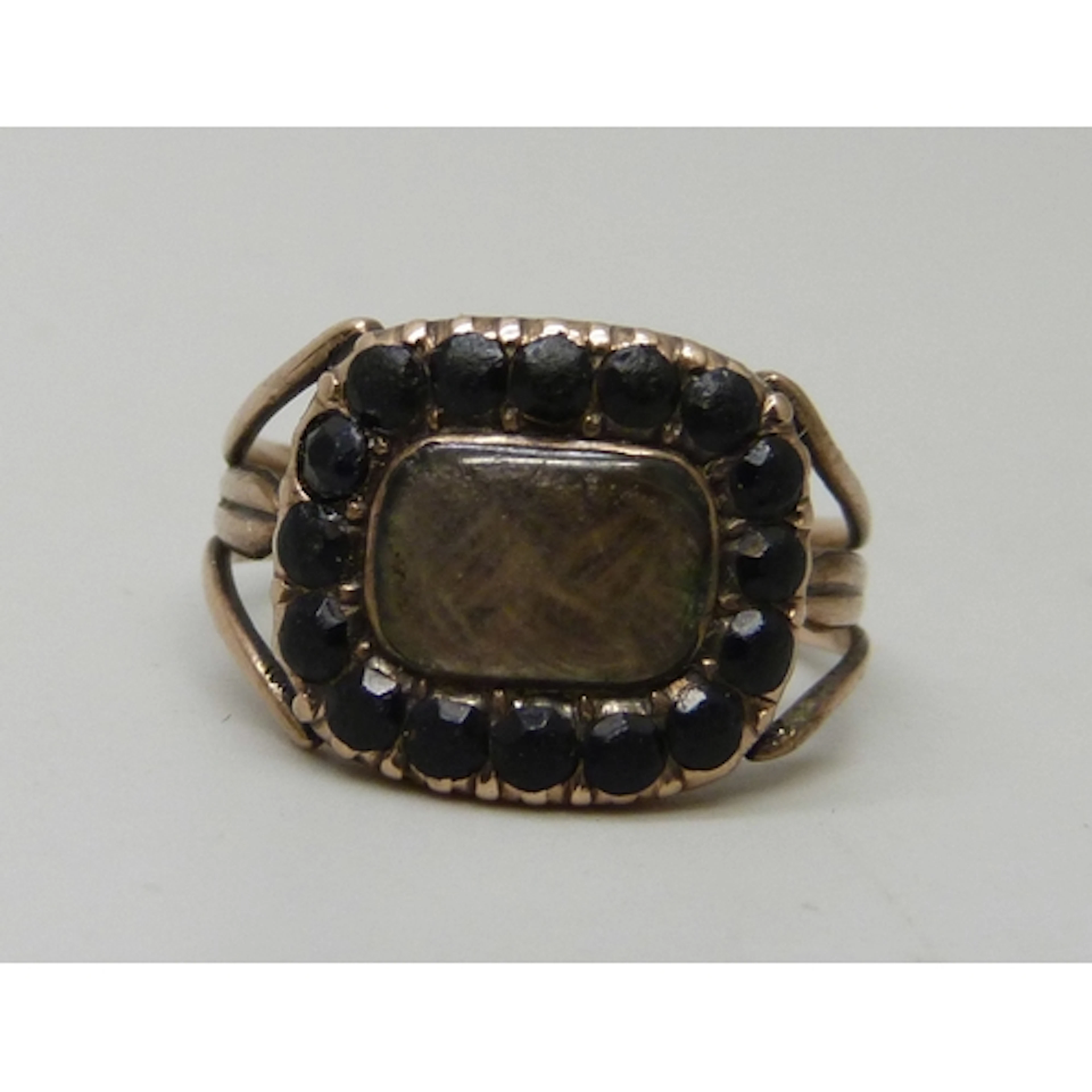 A George III yellow metal mourning ring with hairwork panel,...