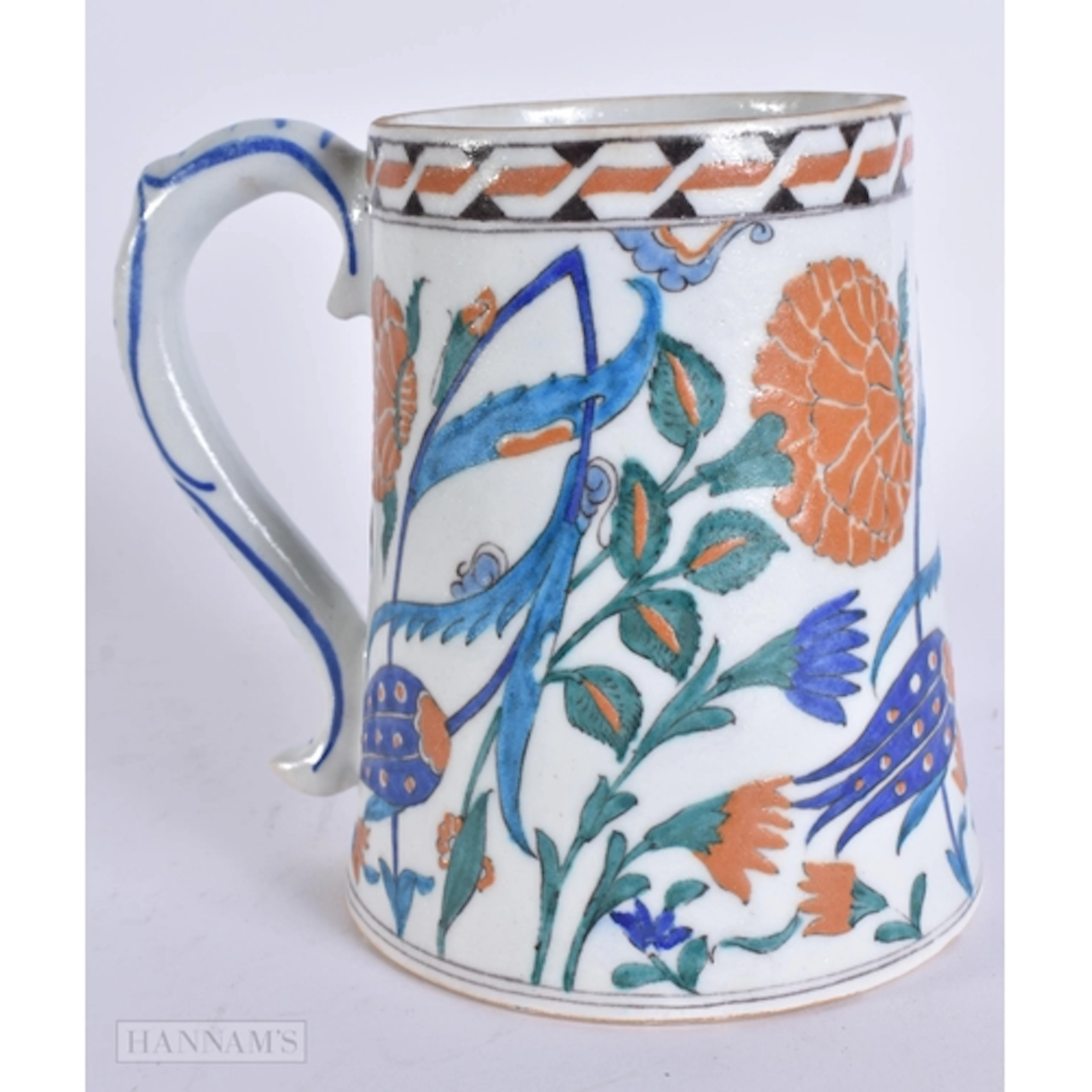 A TURKISH IZNIK POTTERY MUG. 15.5 cm high.