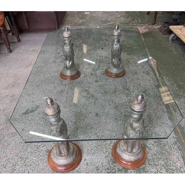An Indian rectangular glass topped coffee table on four figu...