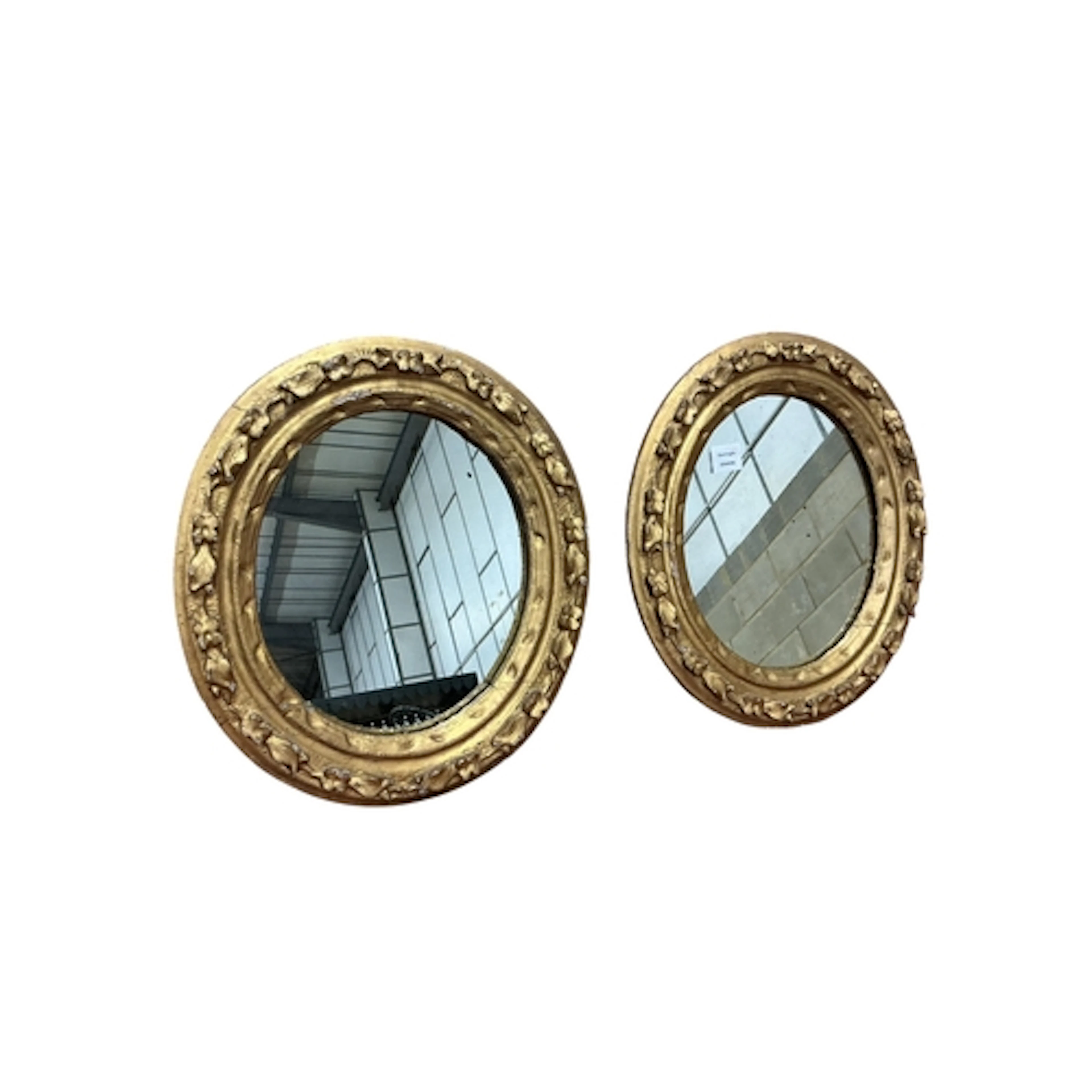 A pair of gilt and composite oval mirrors, width 43cm, heigh...