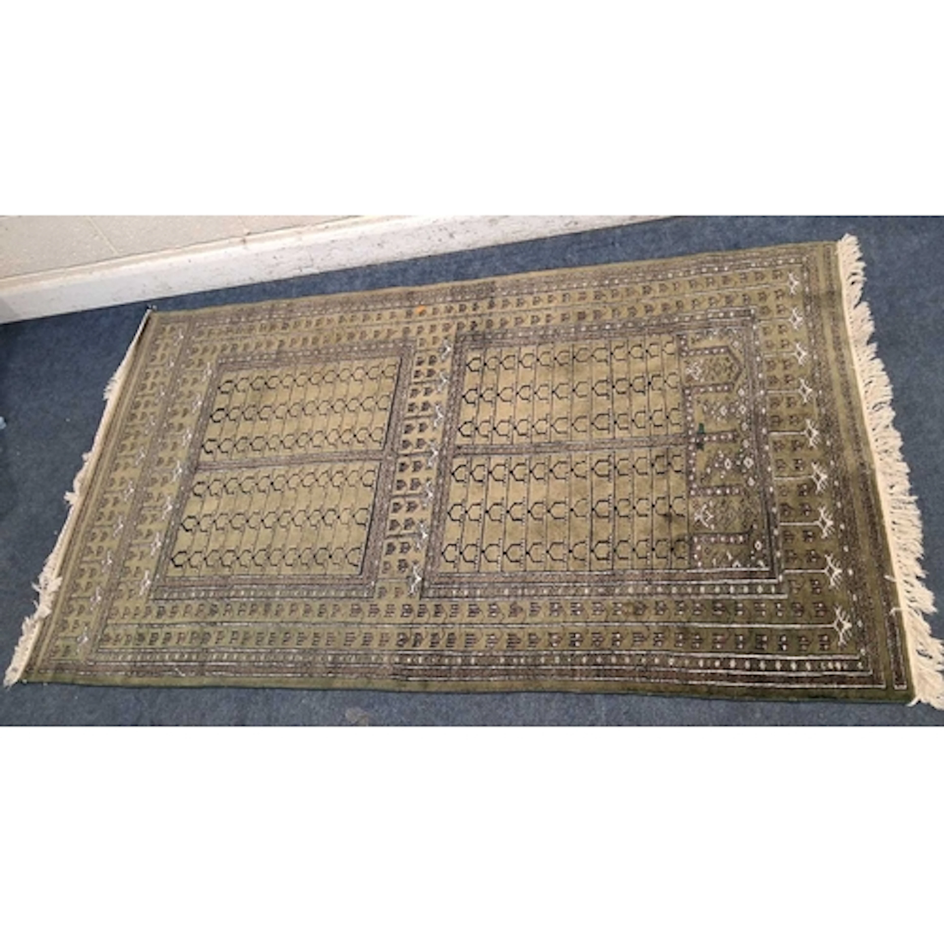 A GREEN GROUND RECTANGULAR WOOLEN RUG, with repeating patter...
