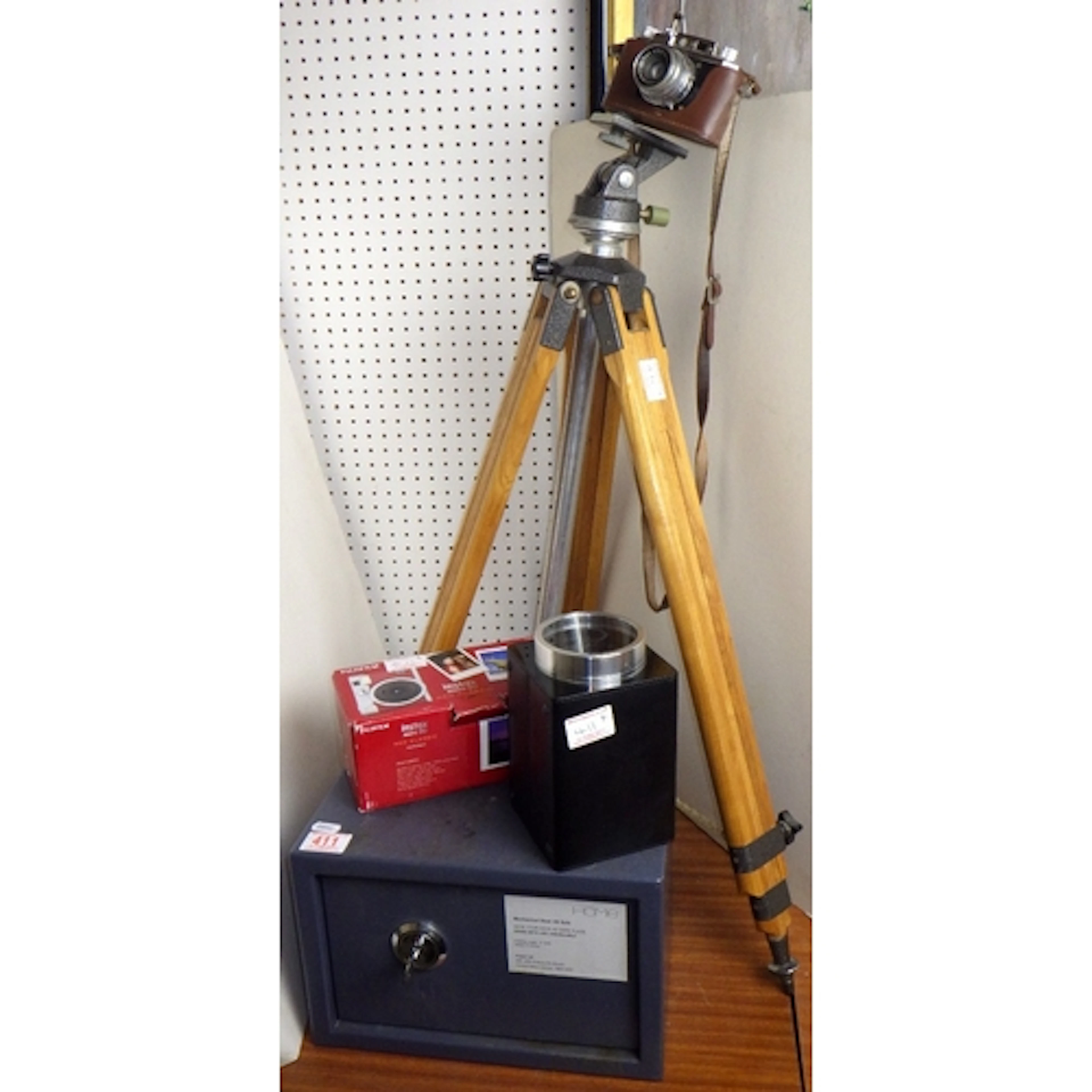 A camera on a tri-pod base, Instax camera, watch winder and ...