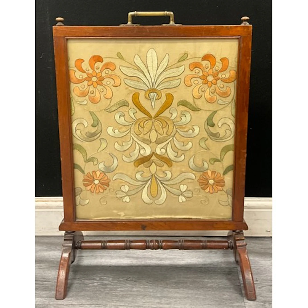 An Edwardian mahogany needlework embroidery fire screen, wit...