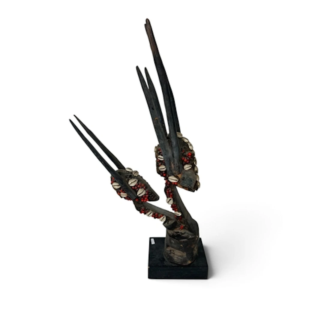 A TRIBAL CARVED WOODEN HEDDLE PULLEY IN THE FORM OF TWO ANTE...
