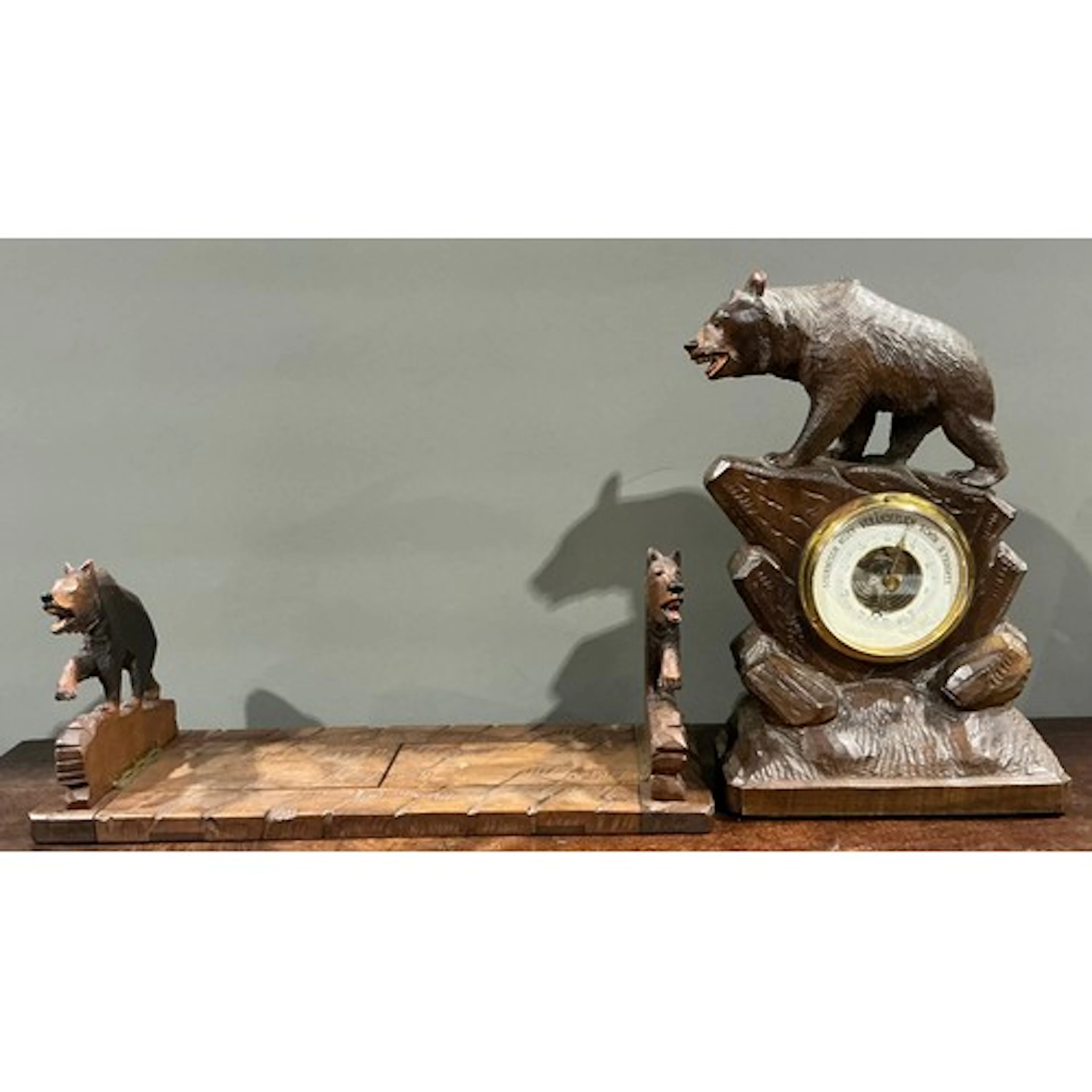 A Black Forest desk or mantel aneroid barometer, carved as a...