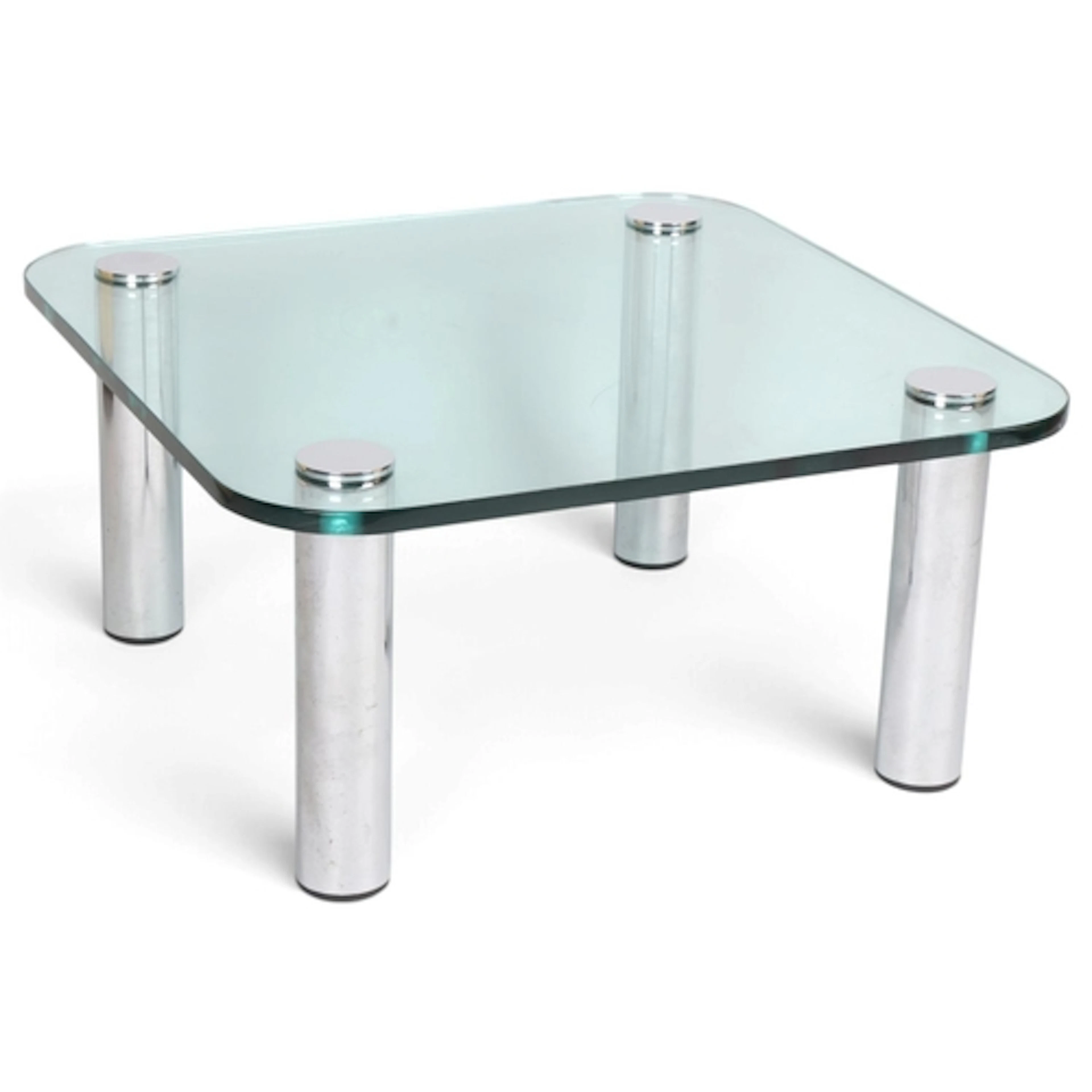 A mid century glass top coffee table on chrome legs in the m...