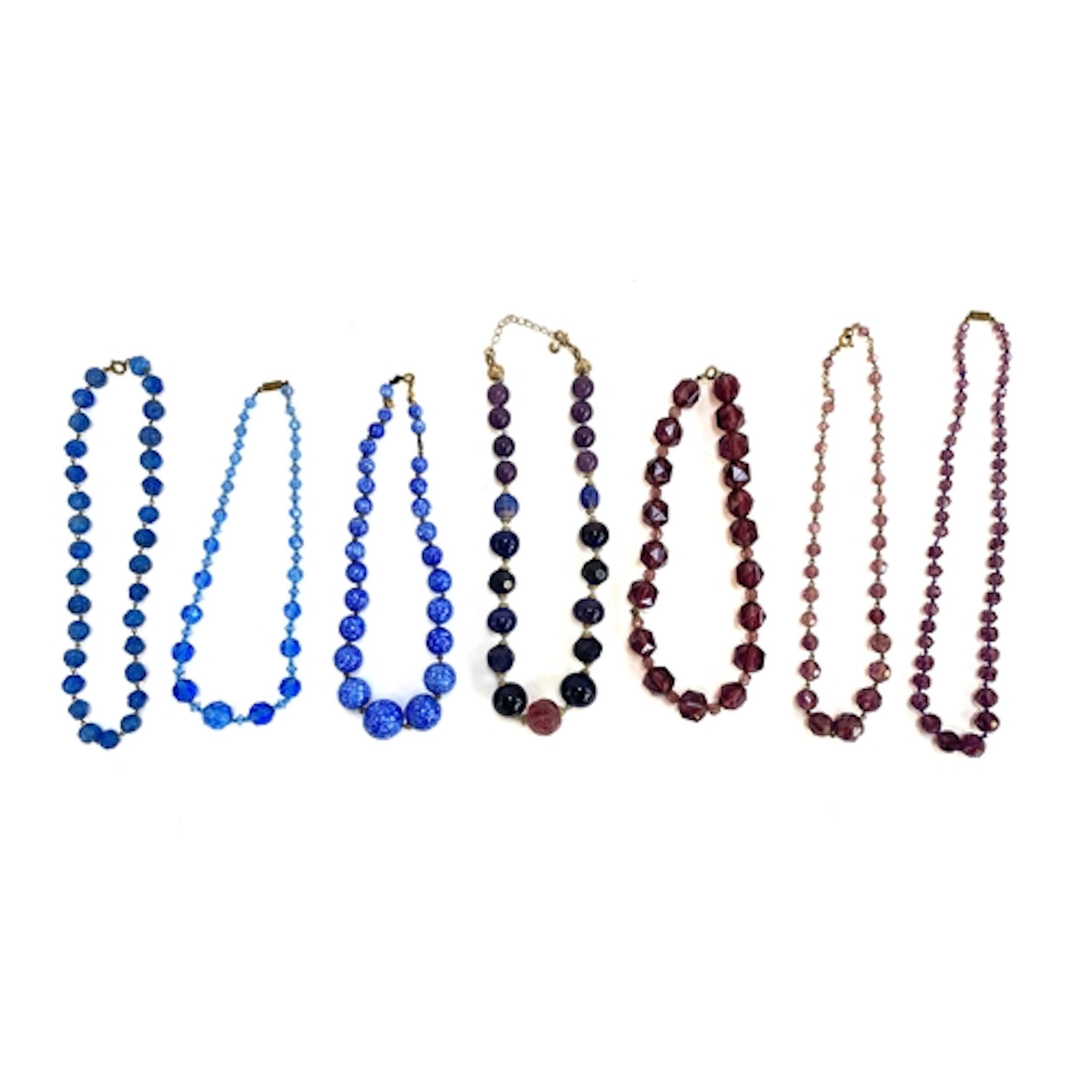 A collection of vintage purple and blue glass beaded necklac...