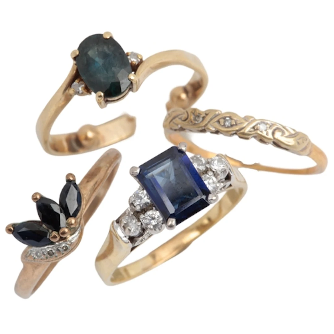 A collection of four rings, comprising: a step-cut synthetic...