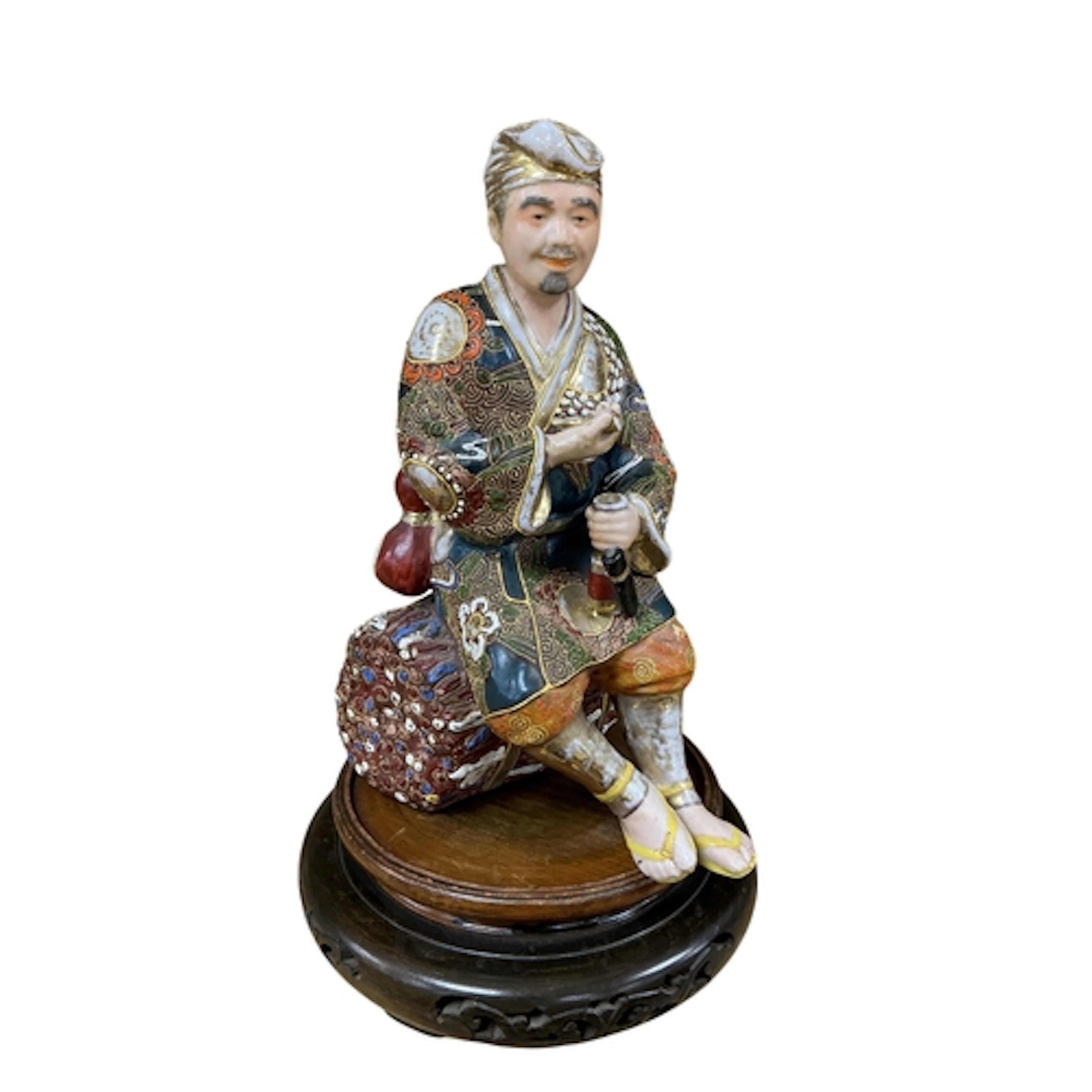 A Japanese Meiji period Satsuma figure of a seated man on as...