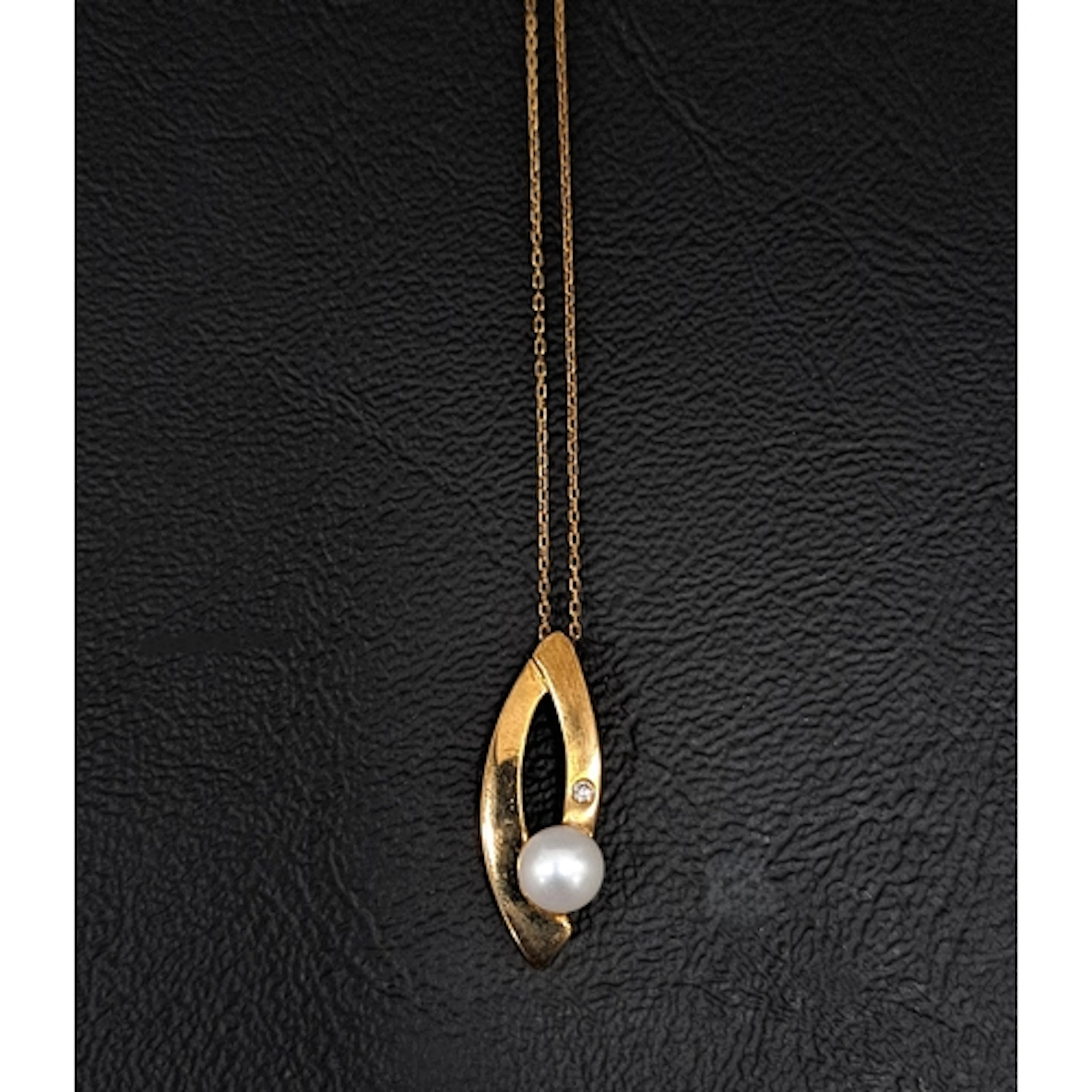 PEARL AND DIAMOND PENDANT in nine carat gold and on nine car...