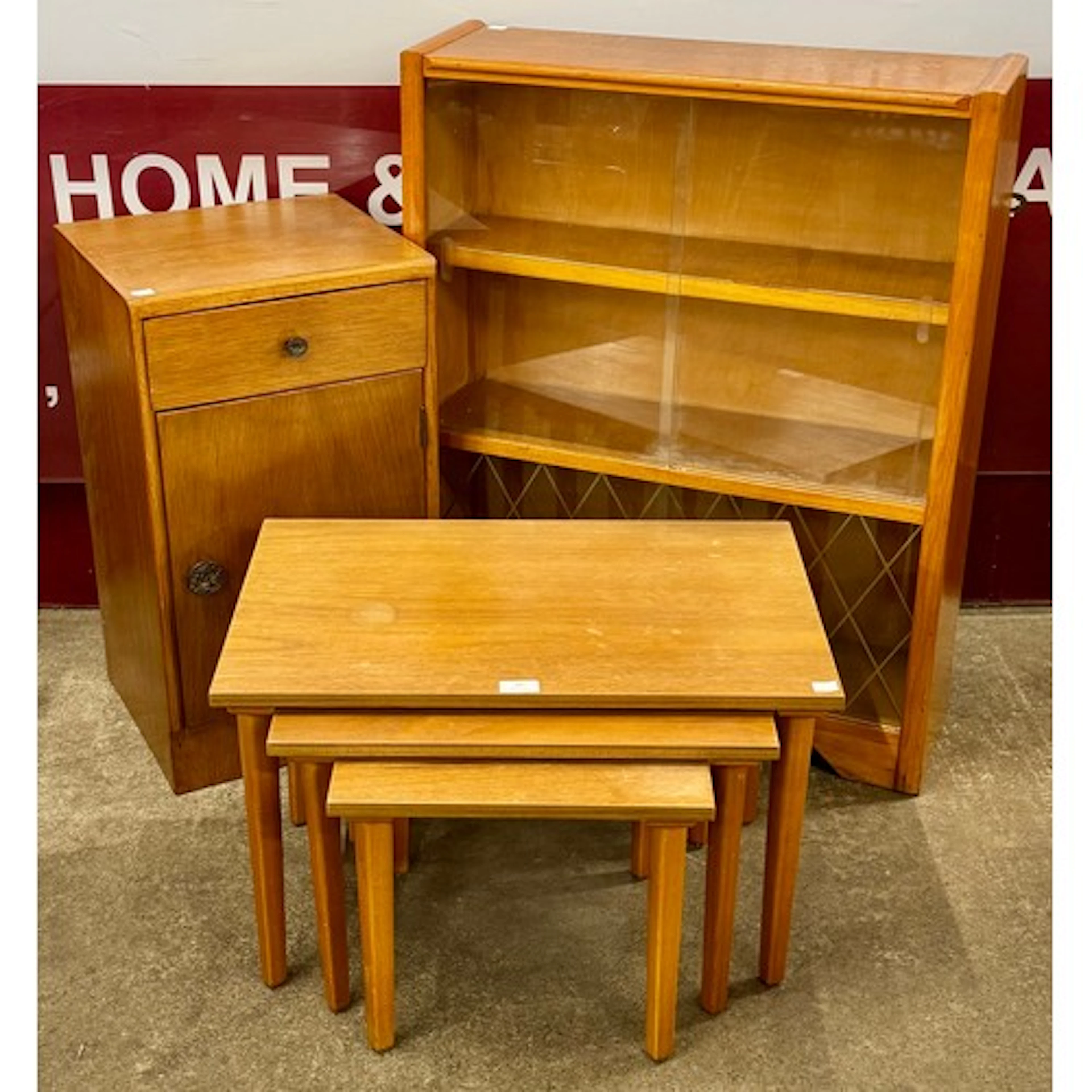 A teak bookcase, nest of tables and a bedside table