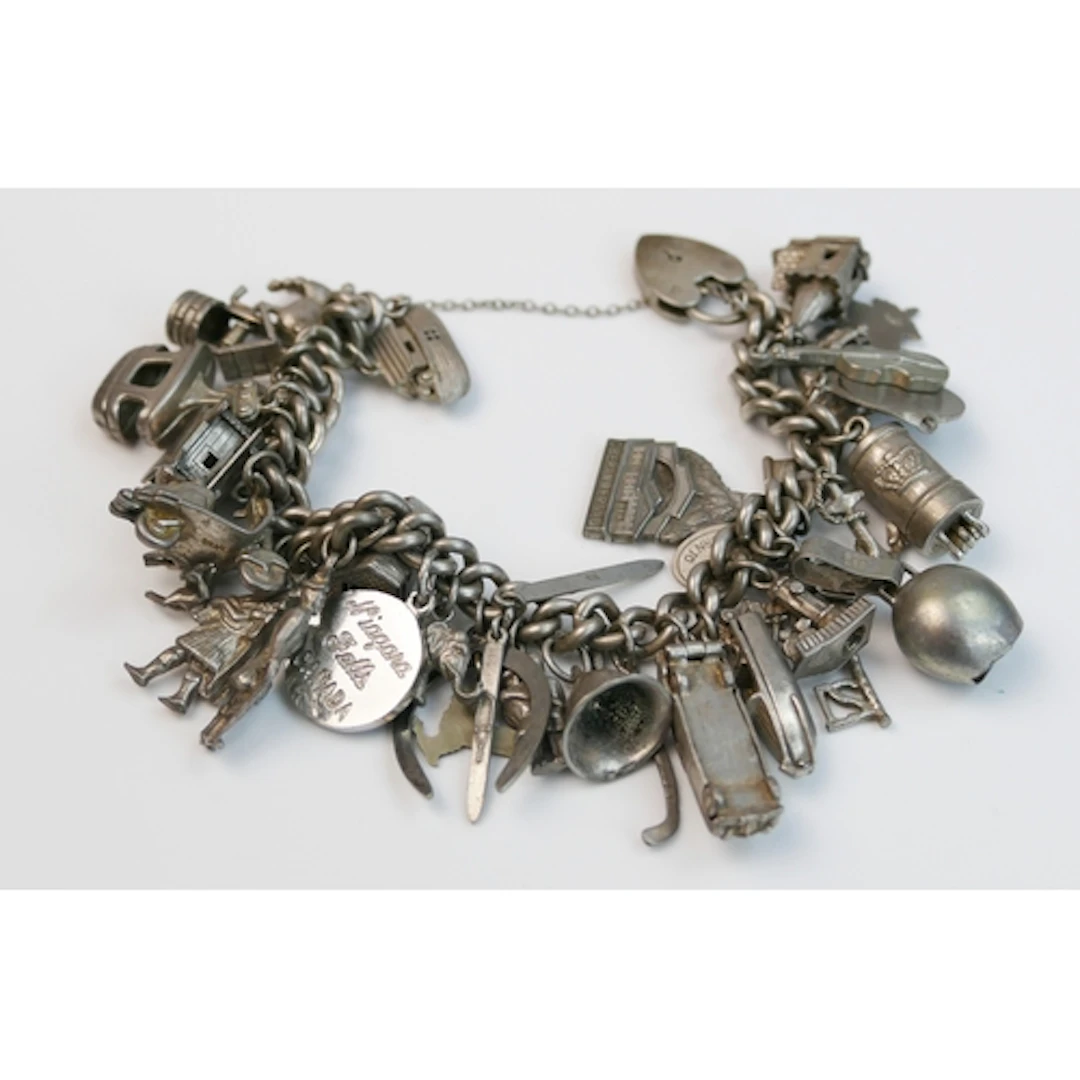 A silver charm bracelet with heart padlock clasp, some charm...