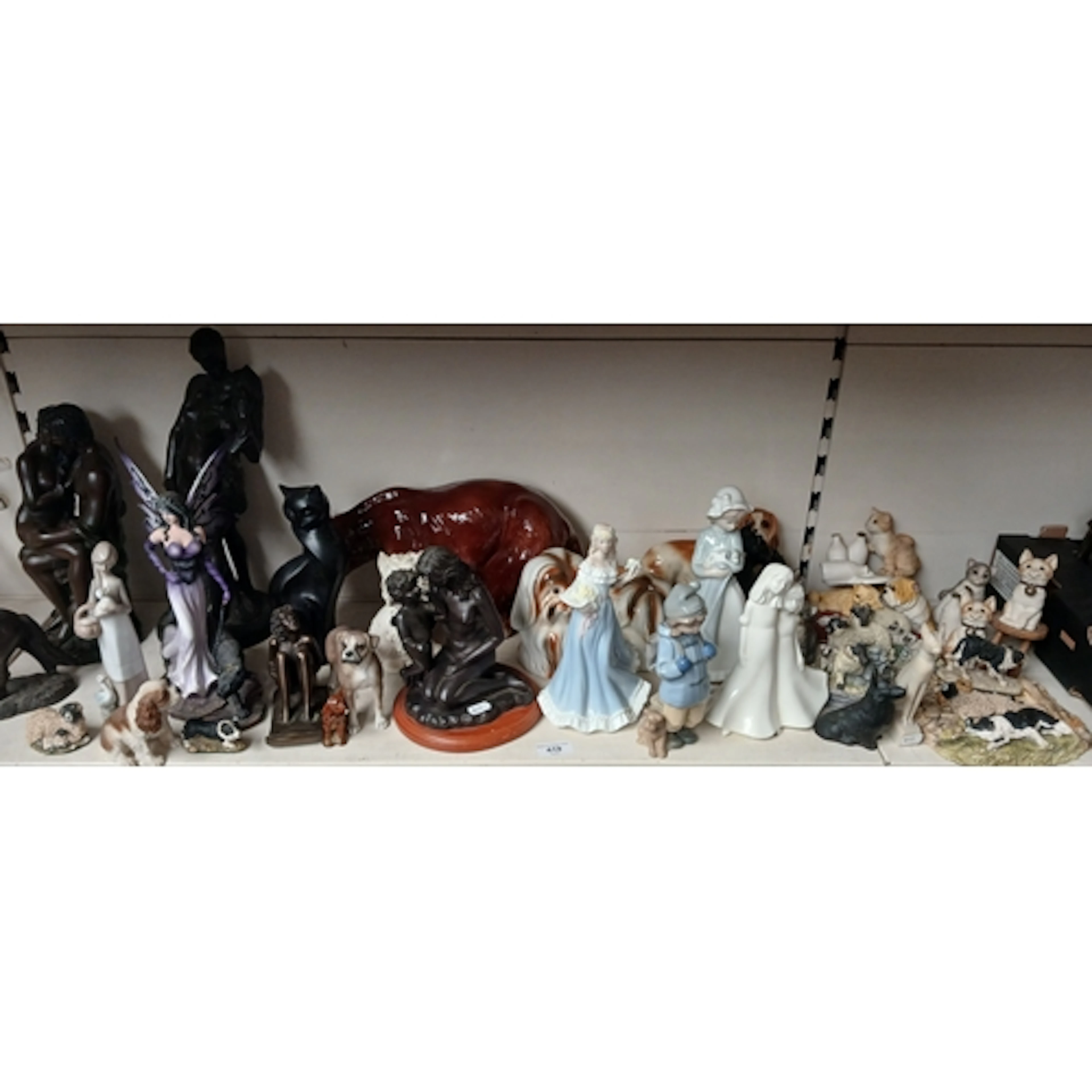 A collection of figurines including ceramic and composite in...