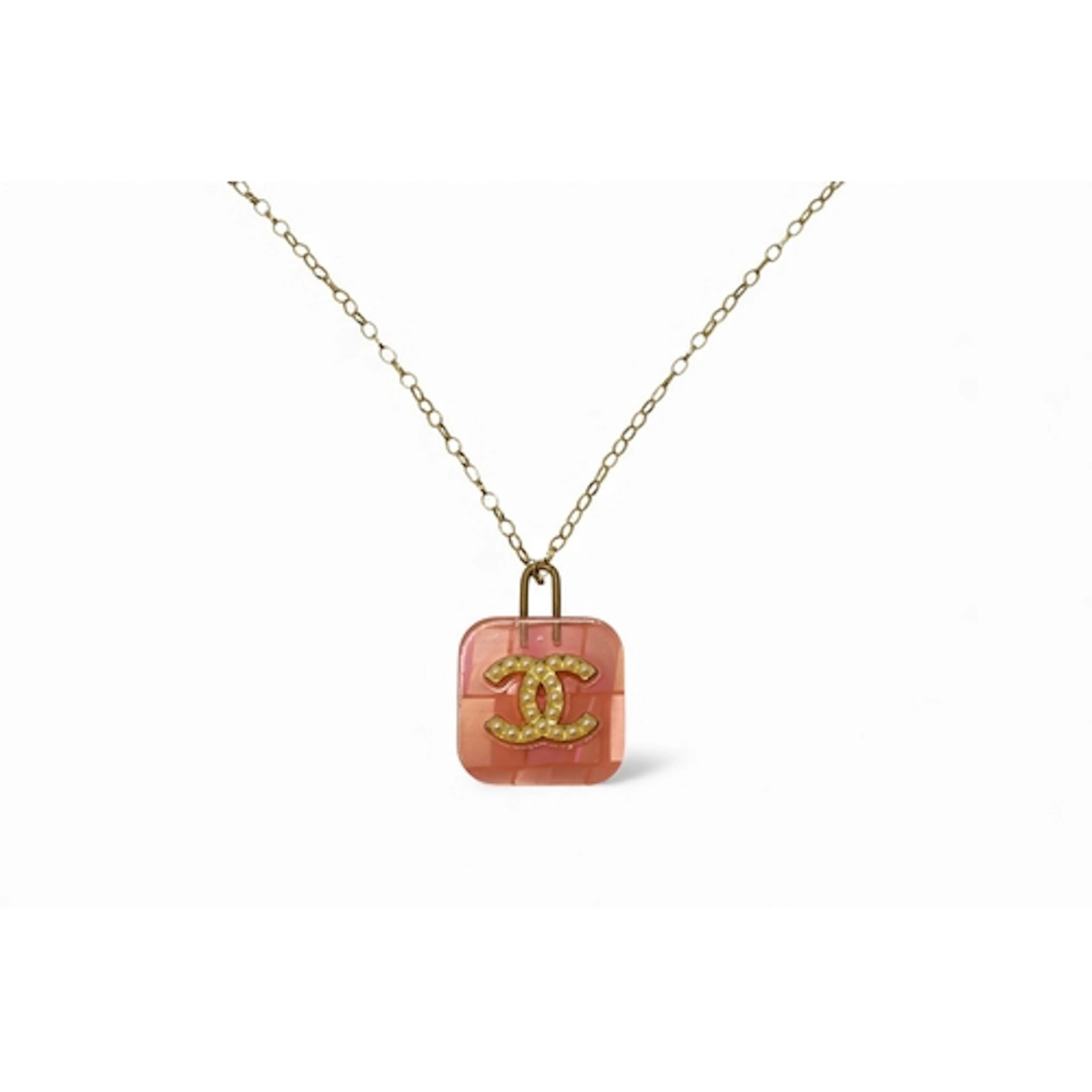 A pink Lucite vintage Chanel pendant the signed button, is s...