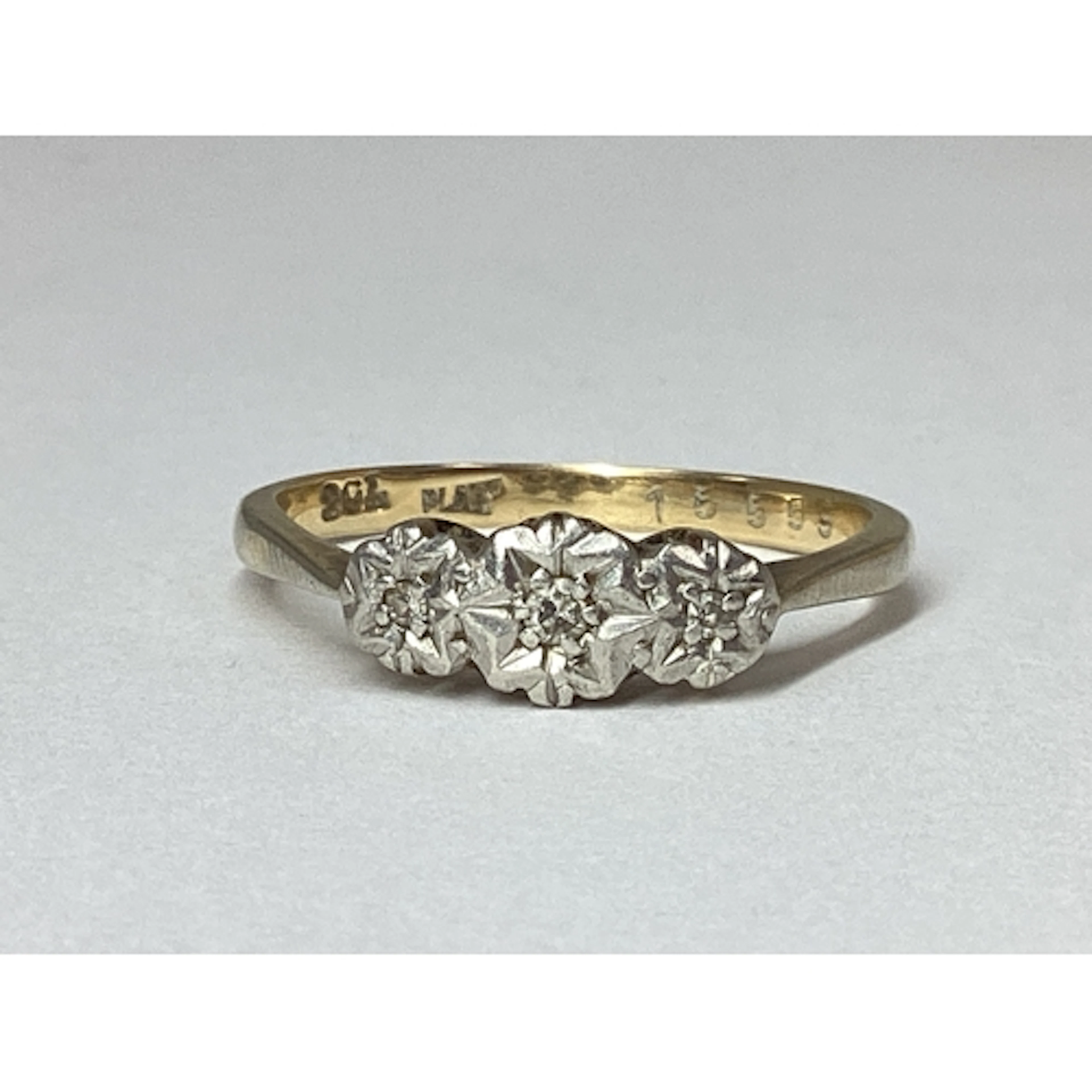 A Three Stone Illusion Set Diamond Ring, between plain taper...