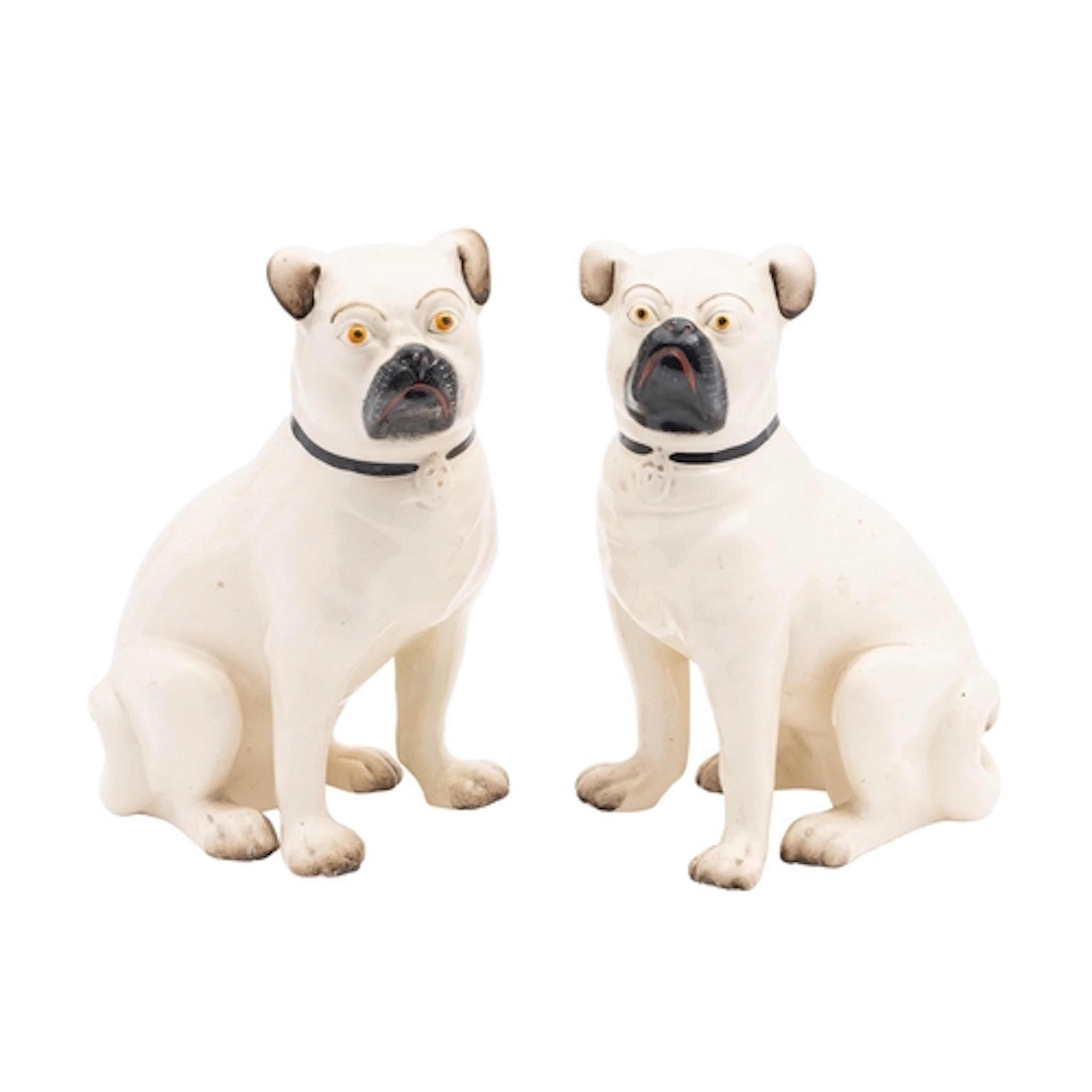 A pair of glazed pottery models of pugs, modelled seated and...