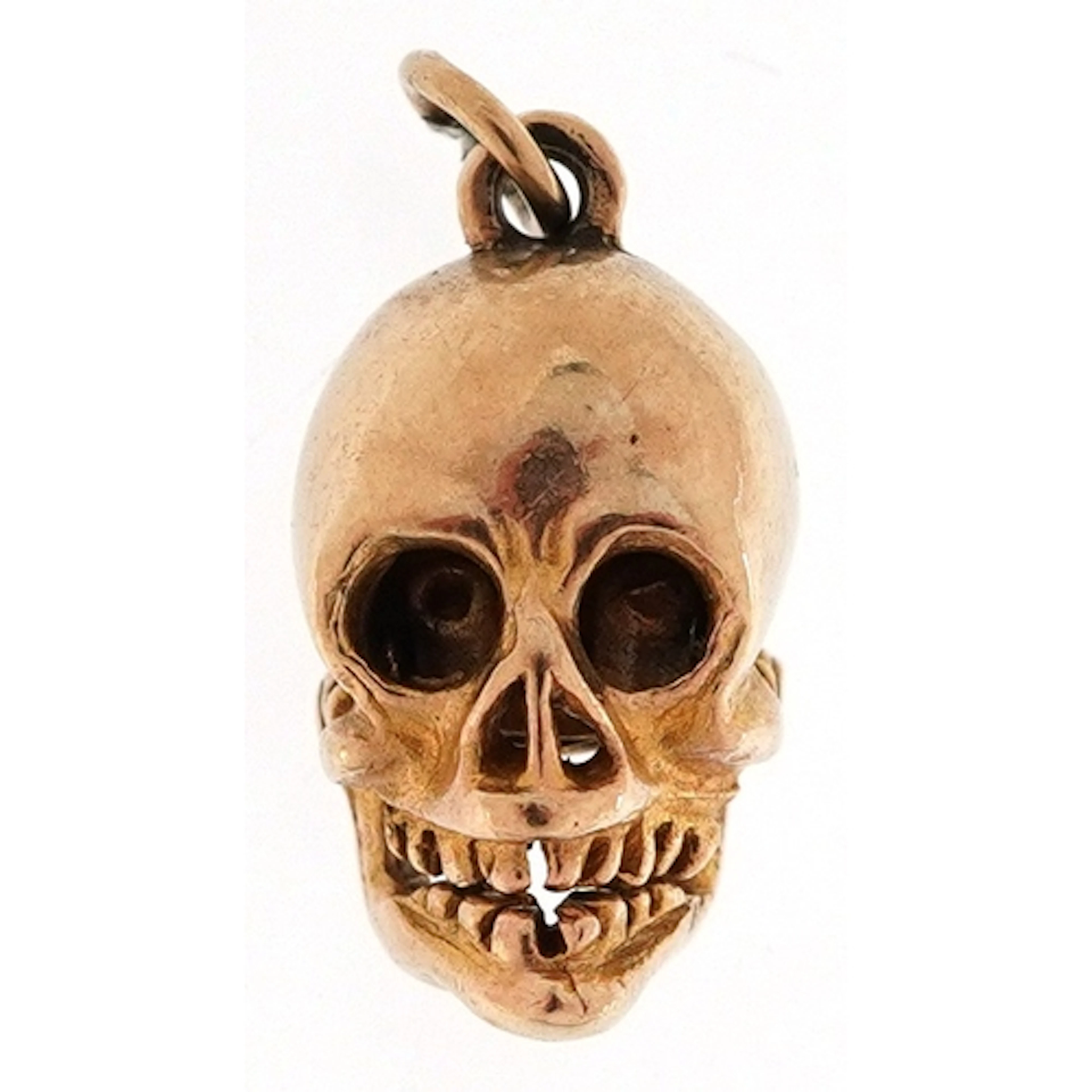 9ct gold charm in the form of a human skull with hinged jaw,...